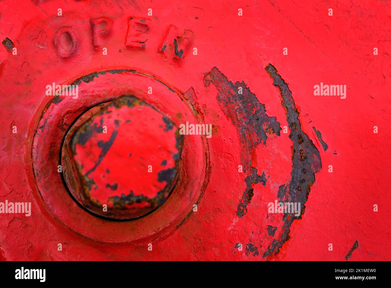 Parte superior del hidrante rojo con la palabra abierta por el perno para la válvula Foto de stock