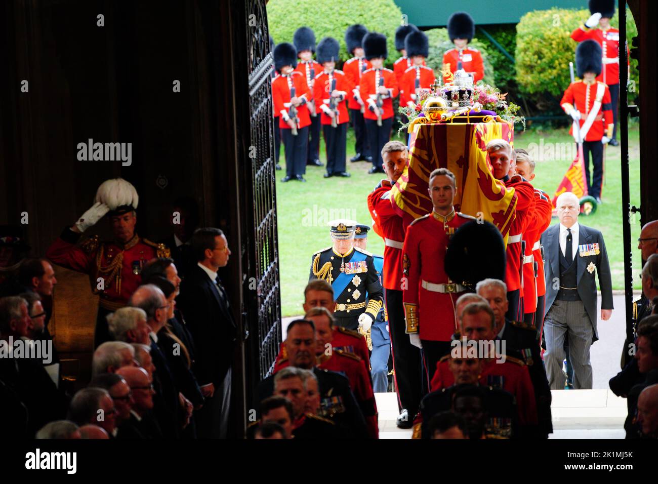 El rey Carlos III (izquierda) sigue como los portadores del ataúd llevan el ataúd de la Reina Isabel II a la Capilla de San Jorge en el Castillo de Windsor, Berkshire, para el Servicio de Compromiso. Fecha de la foto: Lunes 19 de septiembre de 2022. Foto de stock