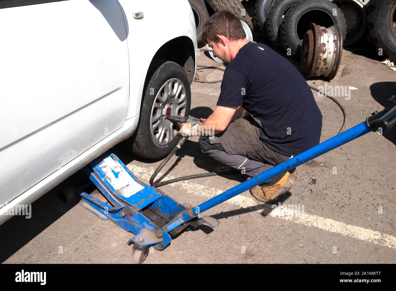 Joven trabajador cambiando bombeo de un neumático en la rueda de un coche en Llandovery Wales Carmarthenshire UK KATHY DEWITT Foto de stock