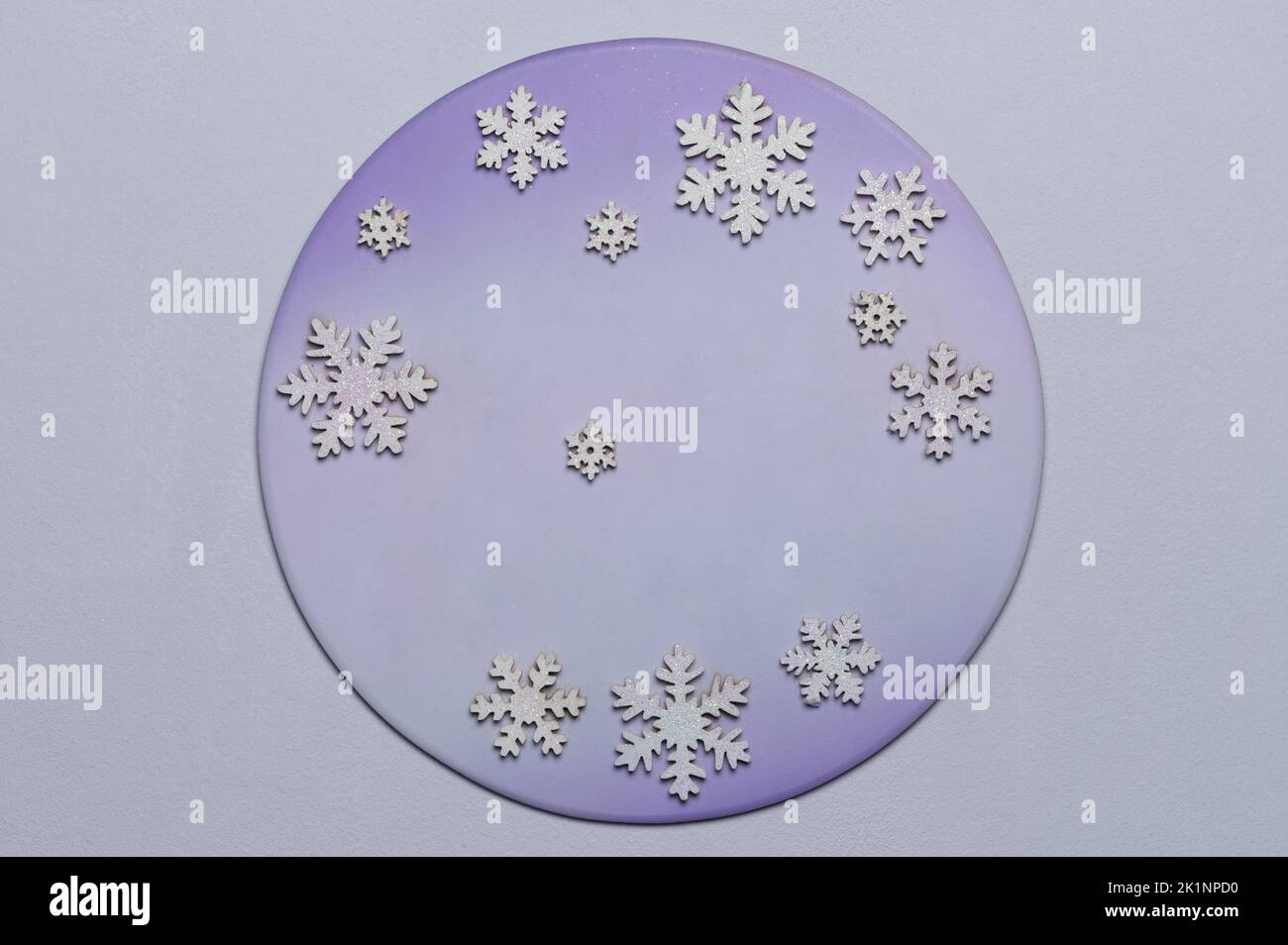 Fondo redondo con copos de nieve sobre superficie de color azul púrpura Foto de stock