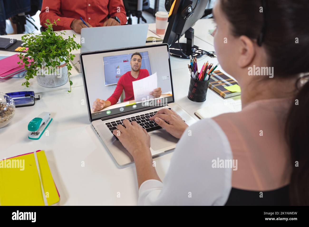 Mujer caucásica planificación con compañero de trabajo masculino en vídeo sobre portátil en la oficina Foto de stock
