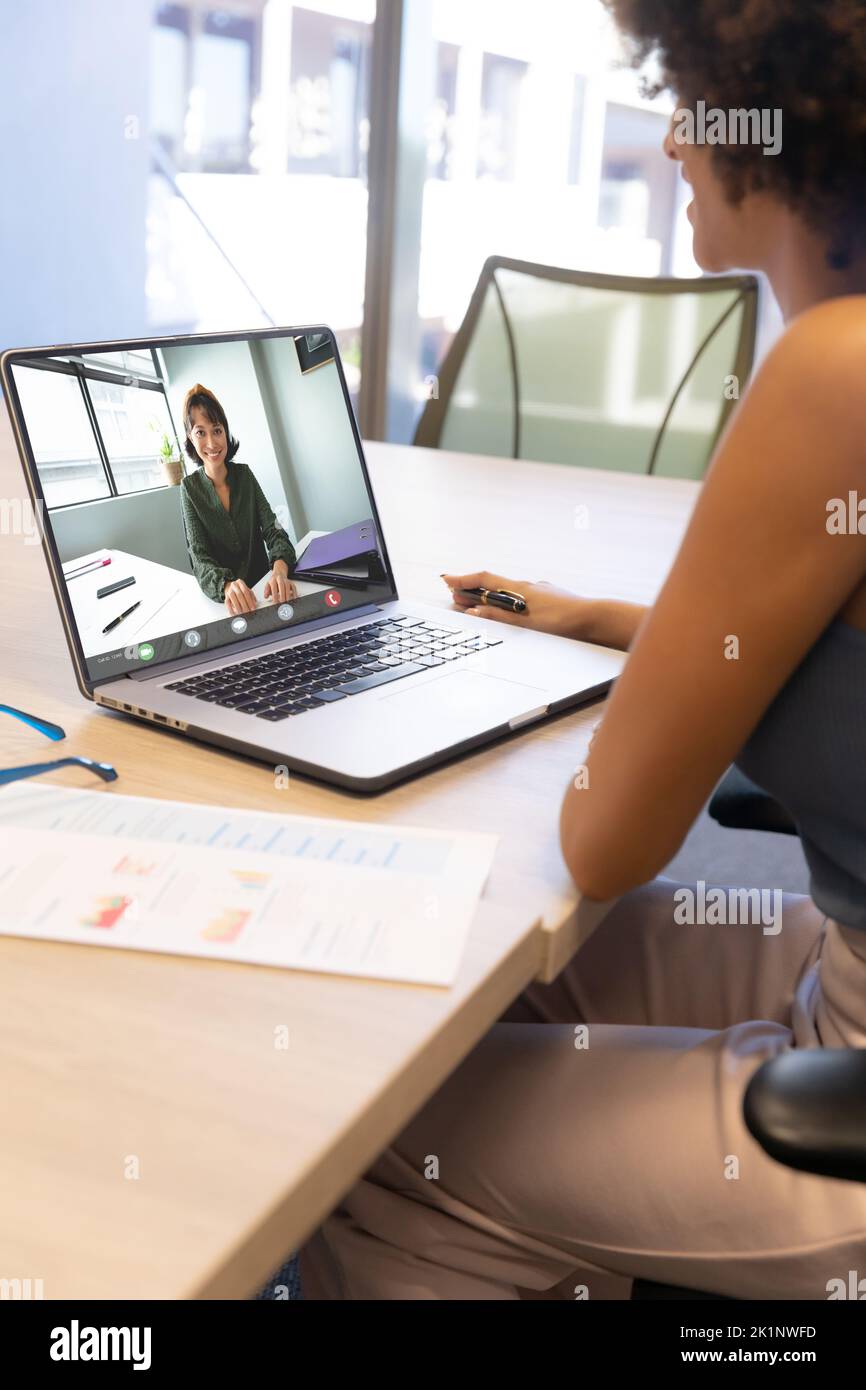 Videoconferencia de mujer de negocios con compañero de trabajo a través de un portátil en la oficina Foto de stock