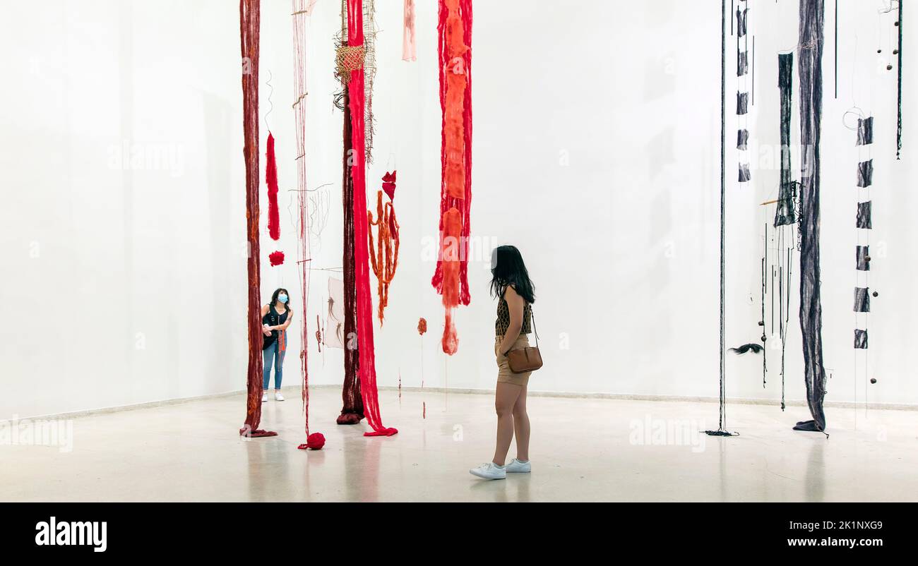 Mujeres en mascarillas ven el arte de la instalación de Cecilia Vicuña, nacida en Chile, en el Museo Guggenheim, Manhattan, Nueva York, EE.UU Foto de stock
