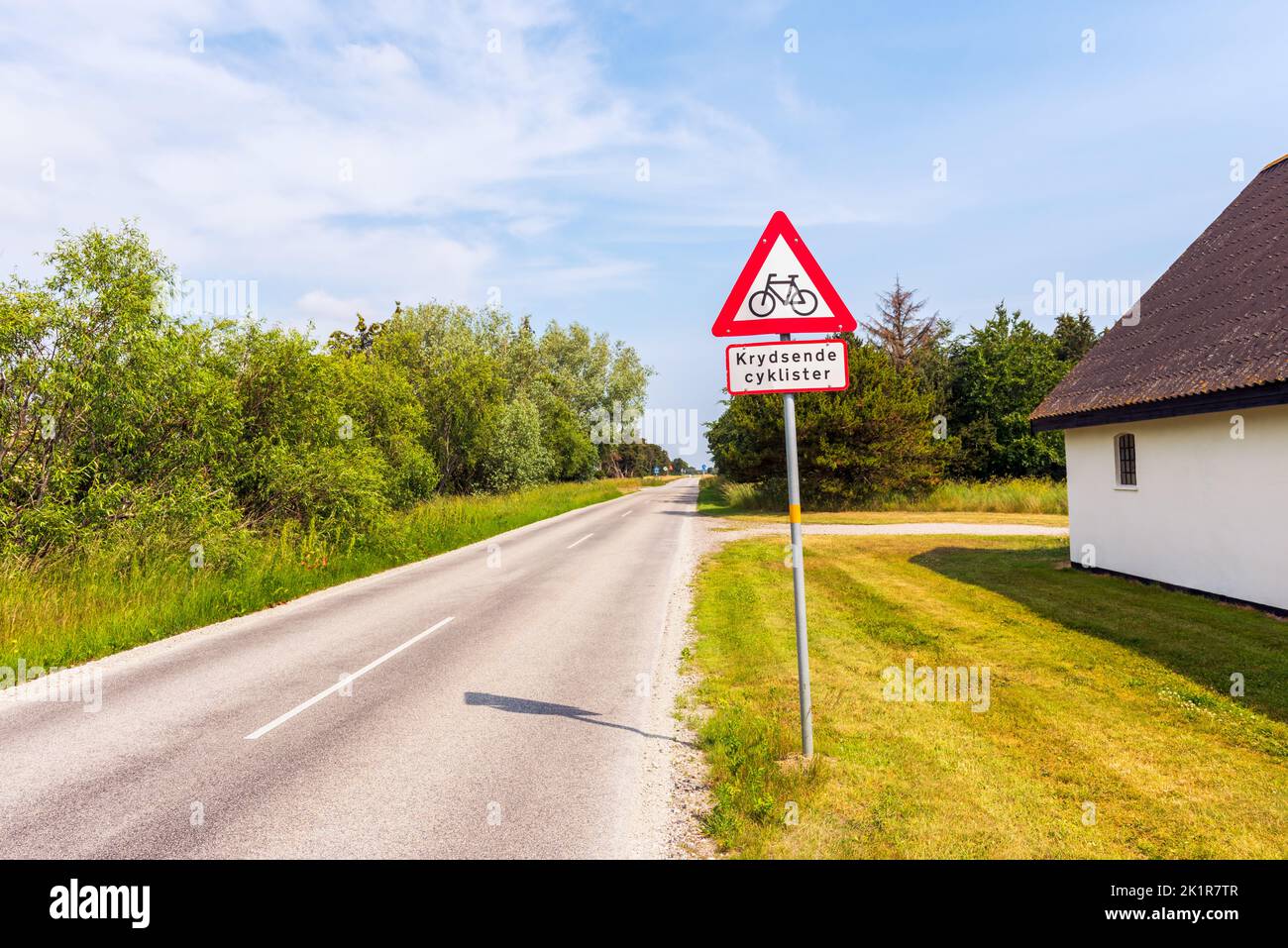 Señal de advertencia para ciclistas que cruzan a lo largo de la carretera en Jutland, Dinamarca, el día de verano Foto de stock