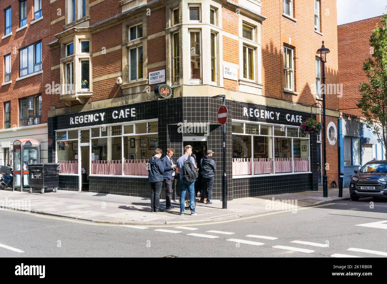Una cola fuera del Regency Cafe en Regency Street, Victoria, Londres. Foto de stock