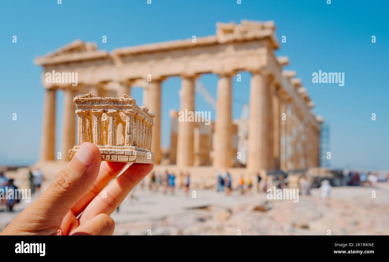 Primer plano de un hombre con una réplica de los restos del Partenón frente al famoso edificio, en la Acrópolis de Atenas, Grecia Foto de stock
