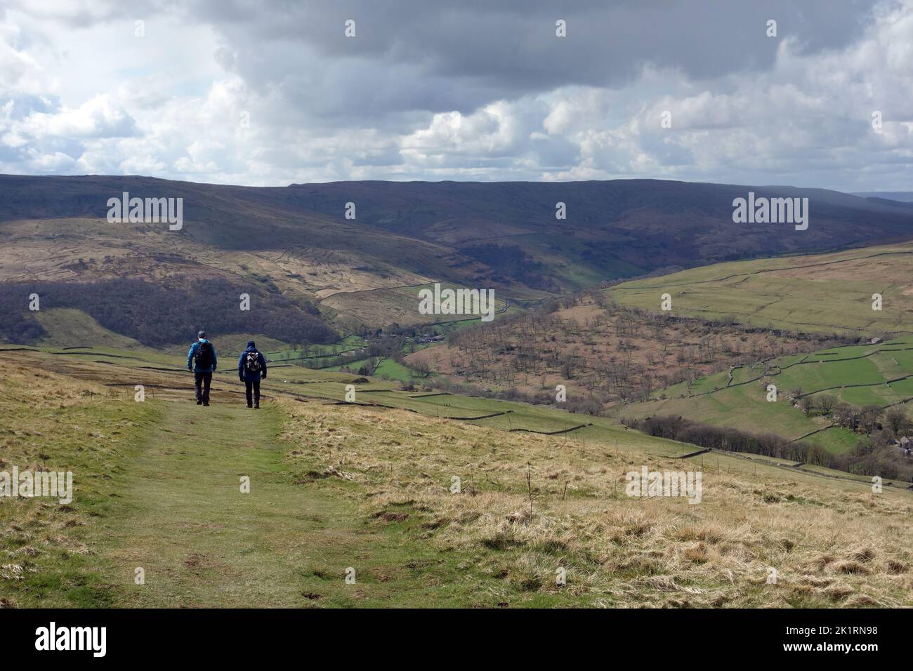 Dos hombres caminando hacia Langstrothdale desde la cumbre de Buckden Pike en Upper Wharfedale en el Parque Nacional Yorkshire Dales, Inglaterra, Reino Unido. Foto de stock