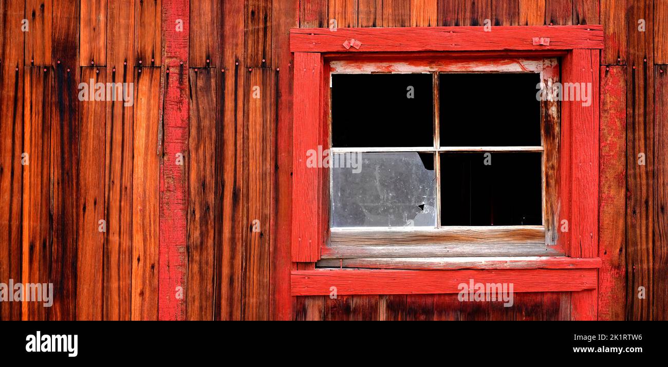 Detalle de la vieja pared de madera envejecida con ventanas y clavos de pintura roja Foto de stock