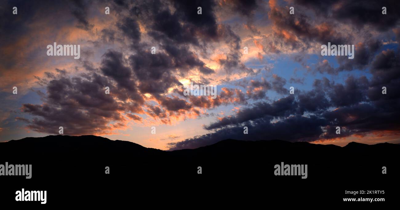 Puesta de sol sobre las montañas desierto con cielo Foto de stock
