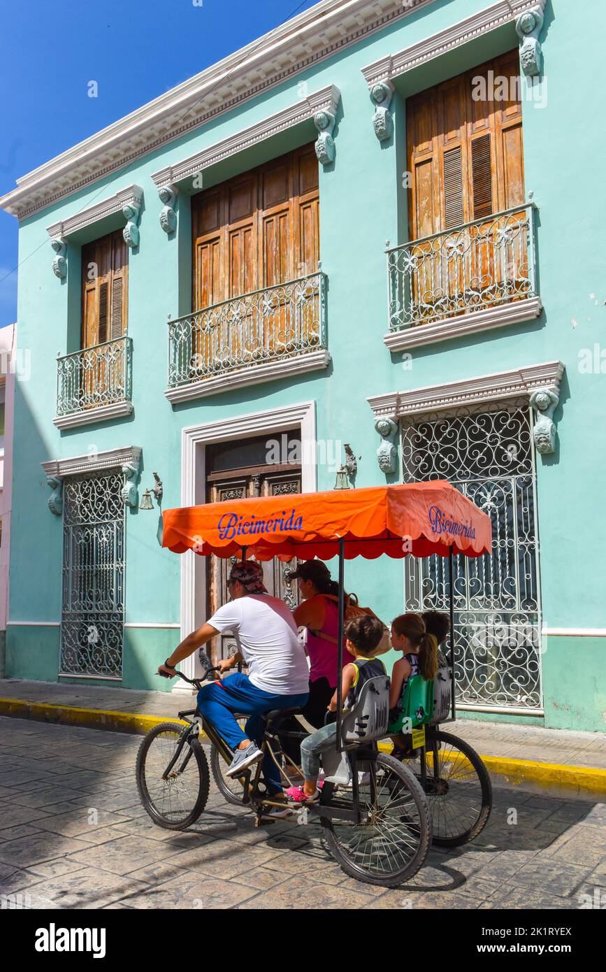 Familia disfrutando de un domingo en un triciclo para la Biciruta Mérida Yucatán que sucede todos los domingos en el centro histórico de esta ciudad mexicana Foto de stock