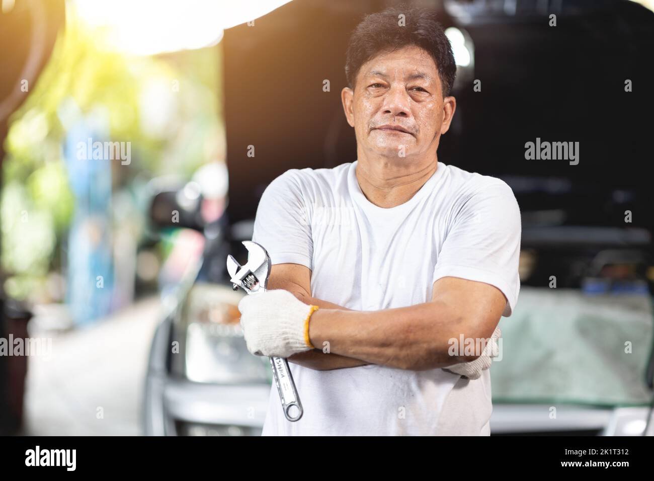 Hombre asiático mecánico profesional retrato feliz sonrisa trabajo hombre en garaje auto servicio Foto de stock