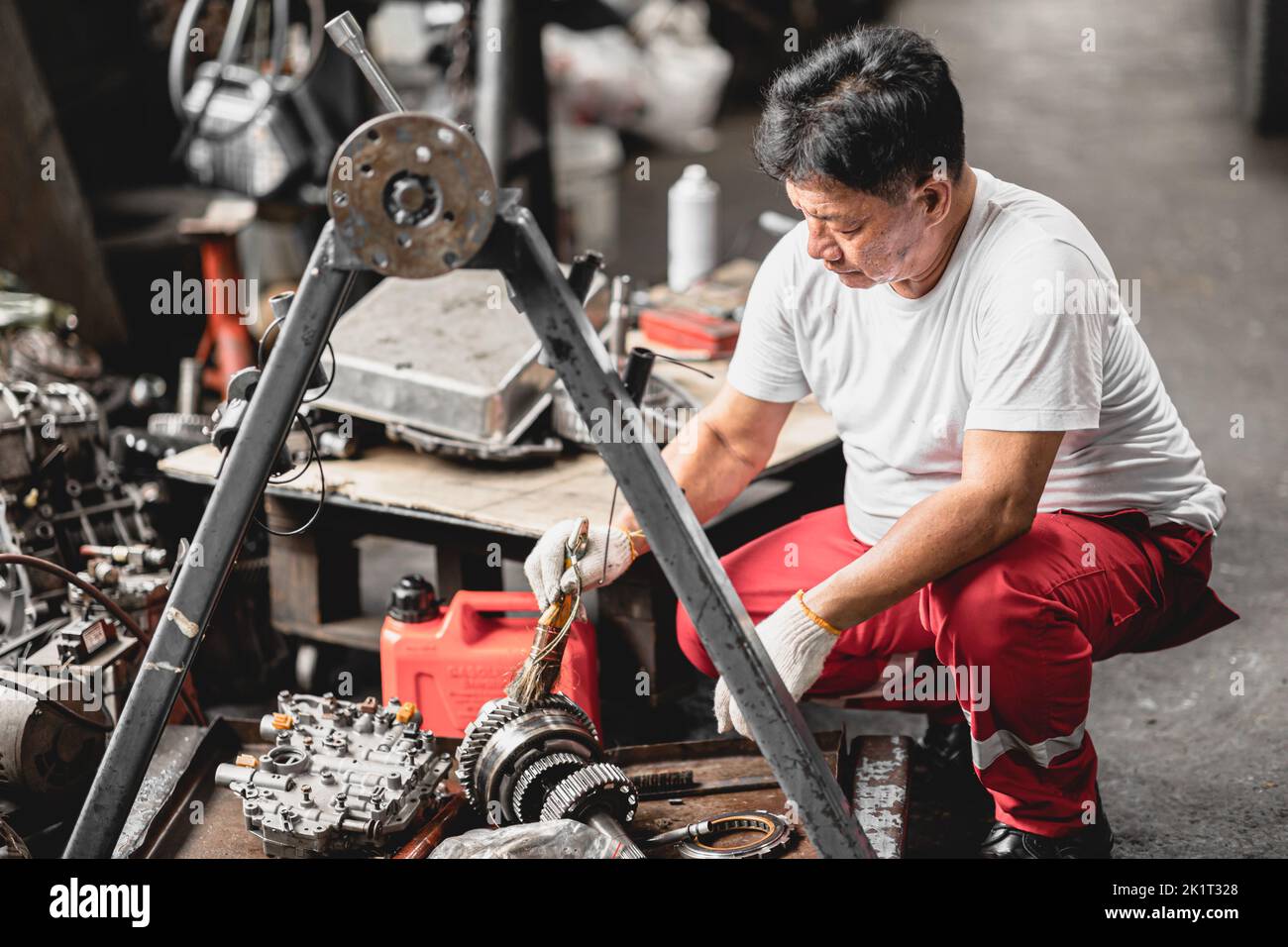 taller mecánico trabajador servicio fijo vehículo trabajo limpieza engranaje auto parte Foto de stock