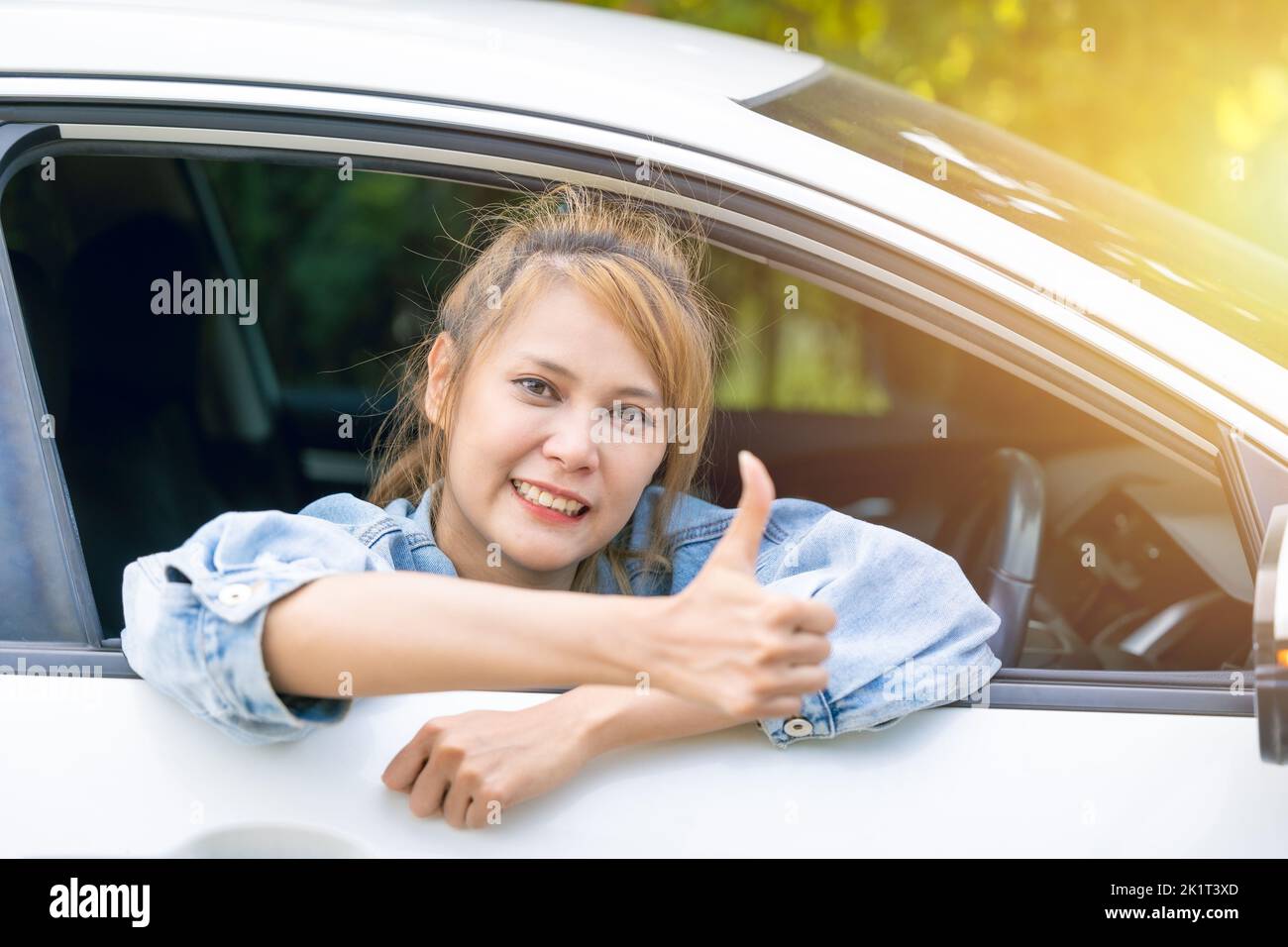 Señora en coche feliz sonriendo Thumb arriba Disfrute conduciendo con buenos viajes. Foto de stock