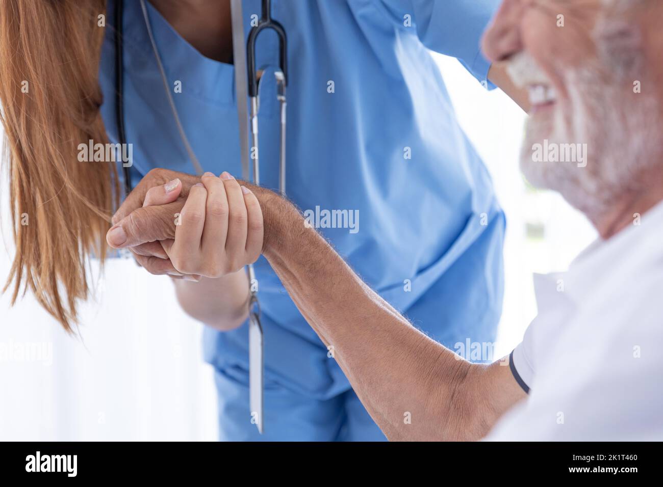 primer plano enfermera doctor sosteniendo la mano del anciano para el apoyo de la atención médica anciano hombre feliz sonriendo Foto de stock