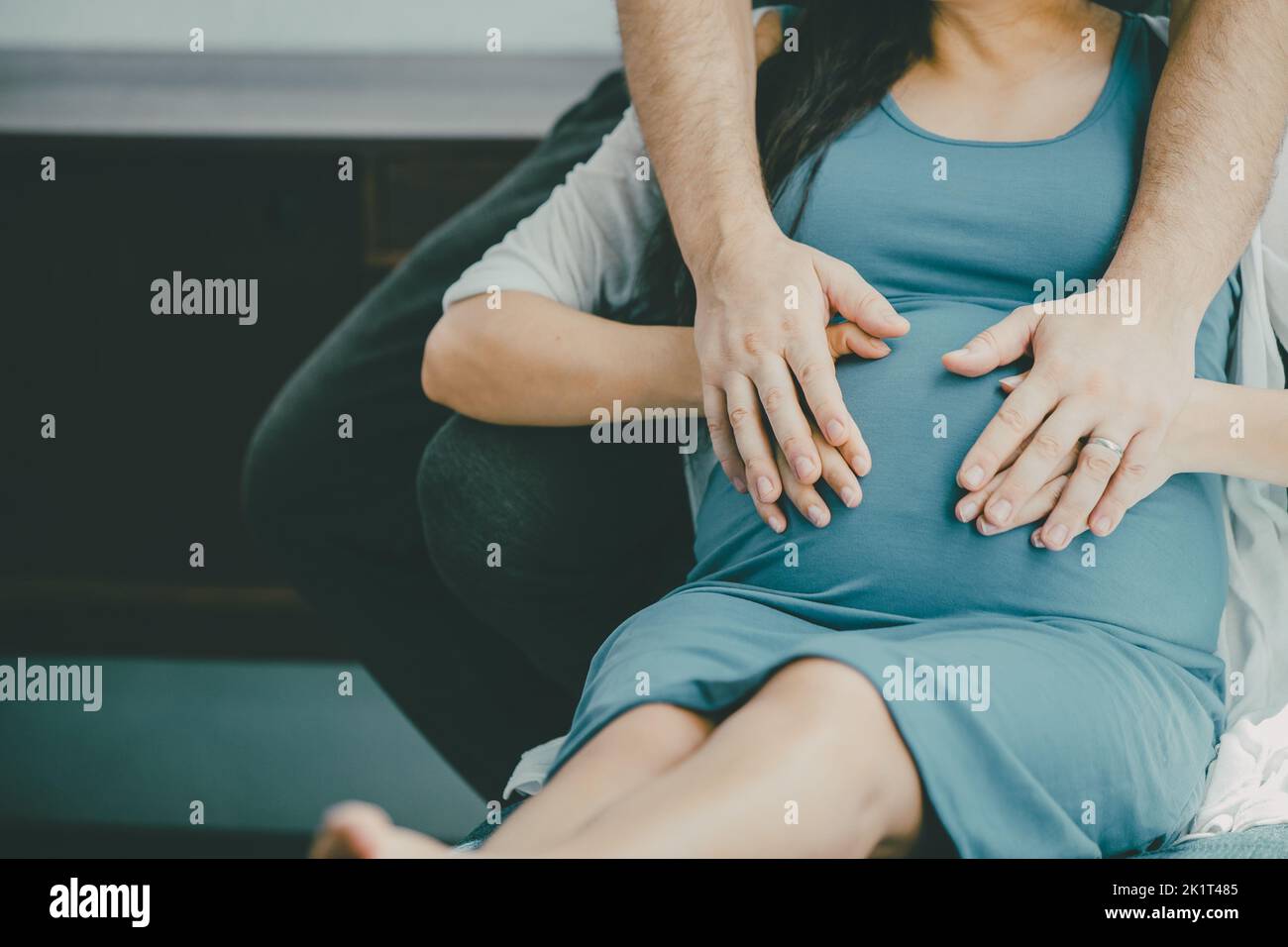 Embarazo mujer marido mano cubrir cuidado proteger para el cuidado del amor bebé en la barriguita Foto de stock