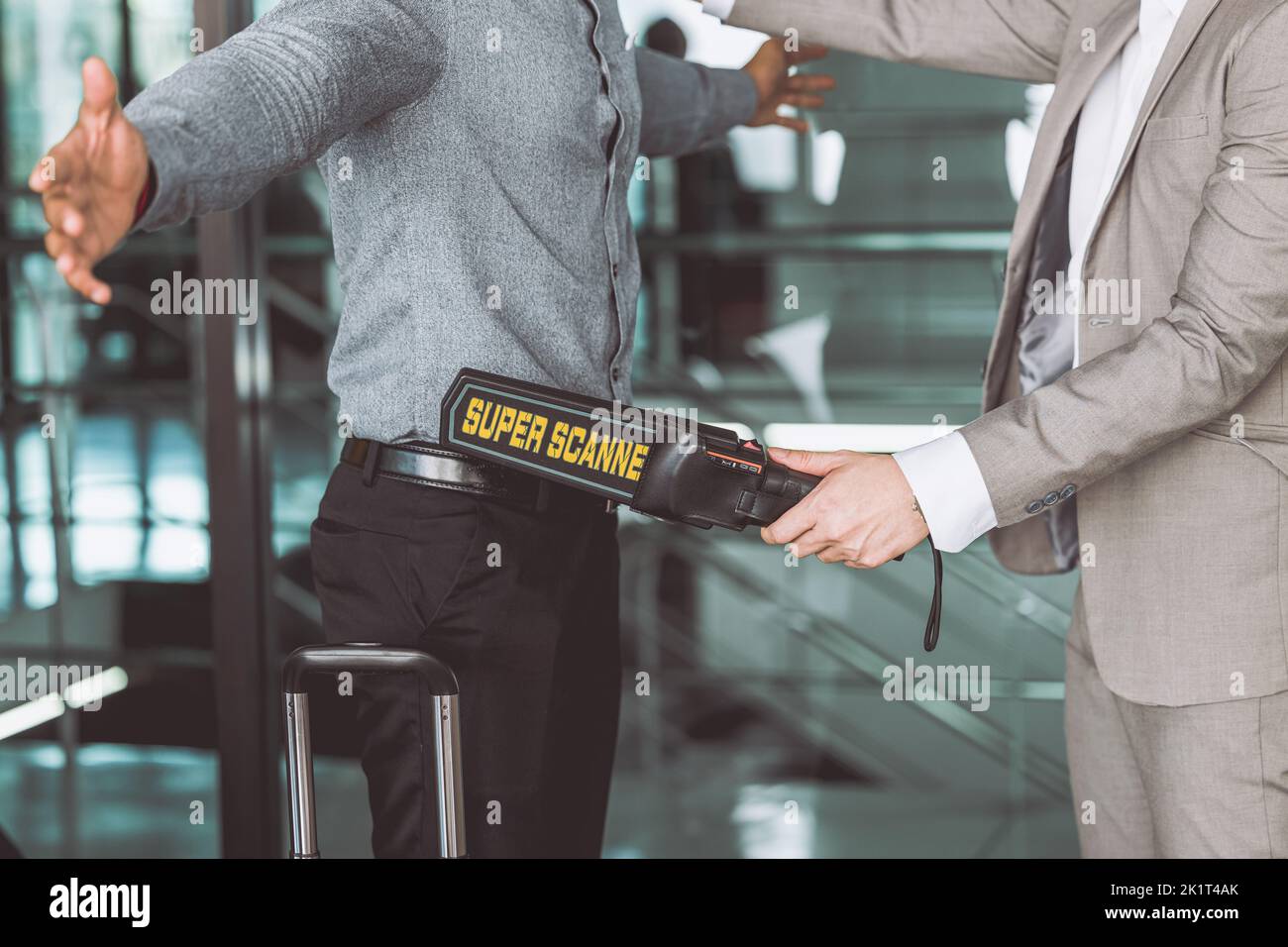 oficial de control de seguridad del aeropuerto que utiliza el detector de escáner de armas de metal chequea cada pasajero Foto de stock