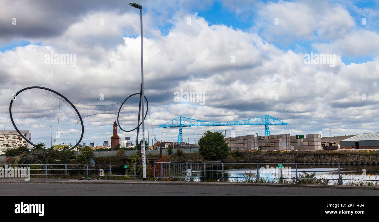 Una vista de la estructura de arte Temenos por Anish Kapoor con la torre del reloj y el puente transportador en segundo plano en Middlesbrough Foto de stock