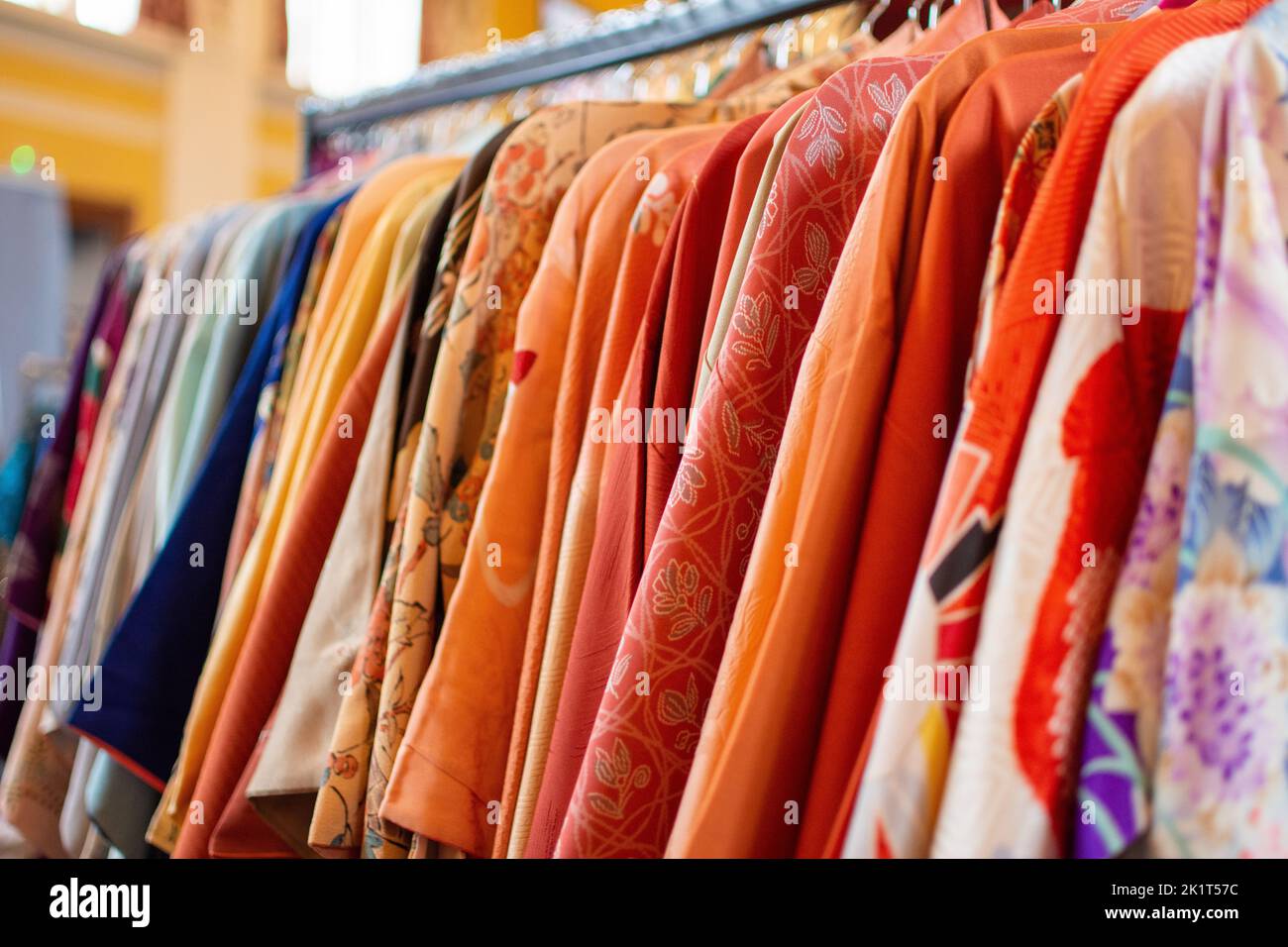 kimono vintage de colores brillantes en la baranda de vestir en la feria vintage Foto de stock