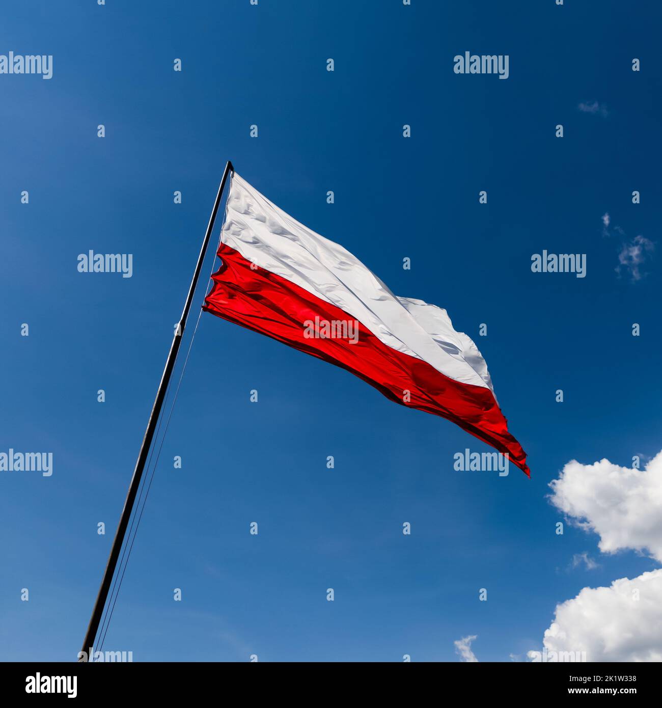 La bandera roja y blanca de Polonia ondea al viento Foto de stock