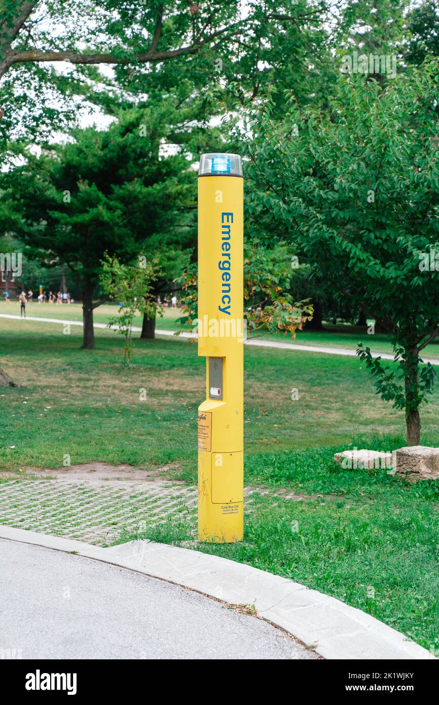 Un poste amarillo de emergencia ubicado en el terreno de un campus escolar Foto de stock