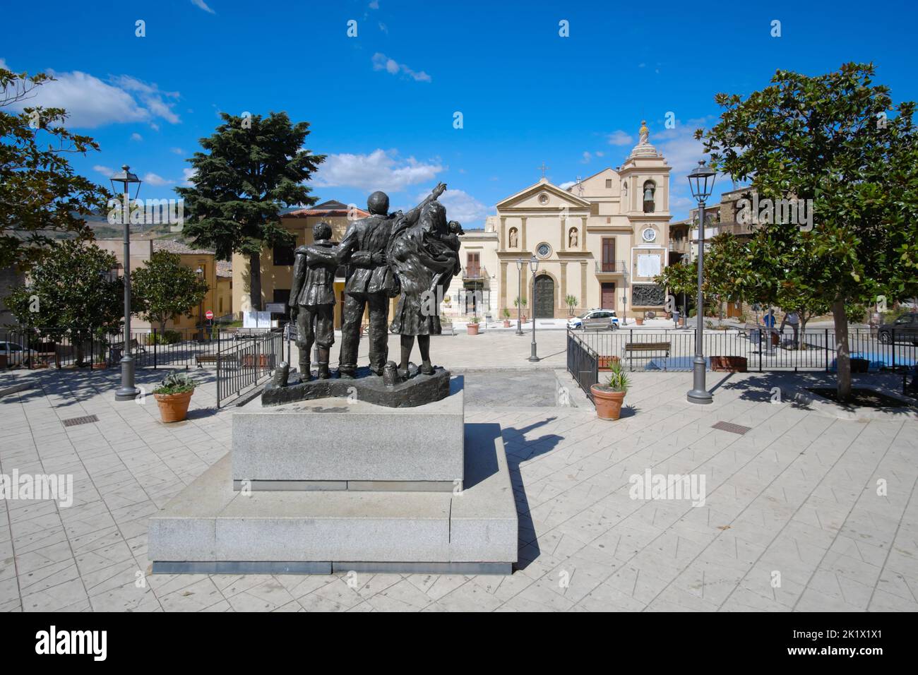La plaza principal de Cefalà Diana con el monumento a los emigrantes y la iglesia de San Francesco di Paola en Sicilia, Italia Foto de stock