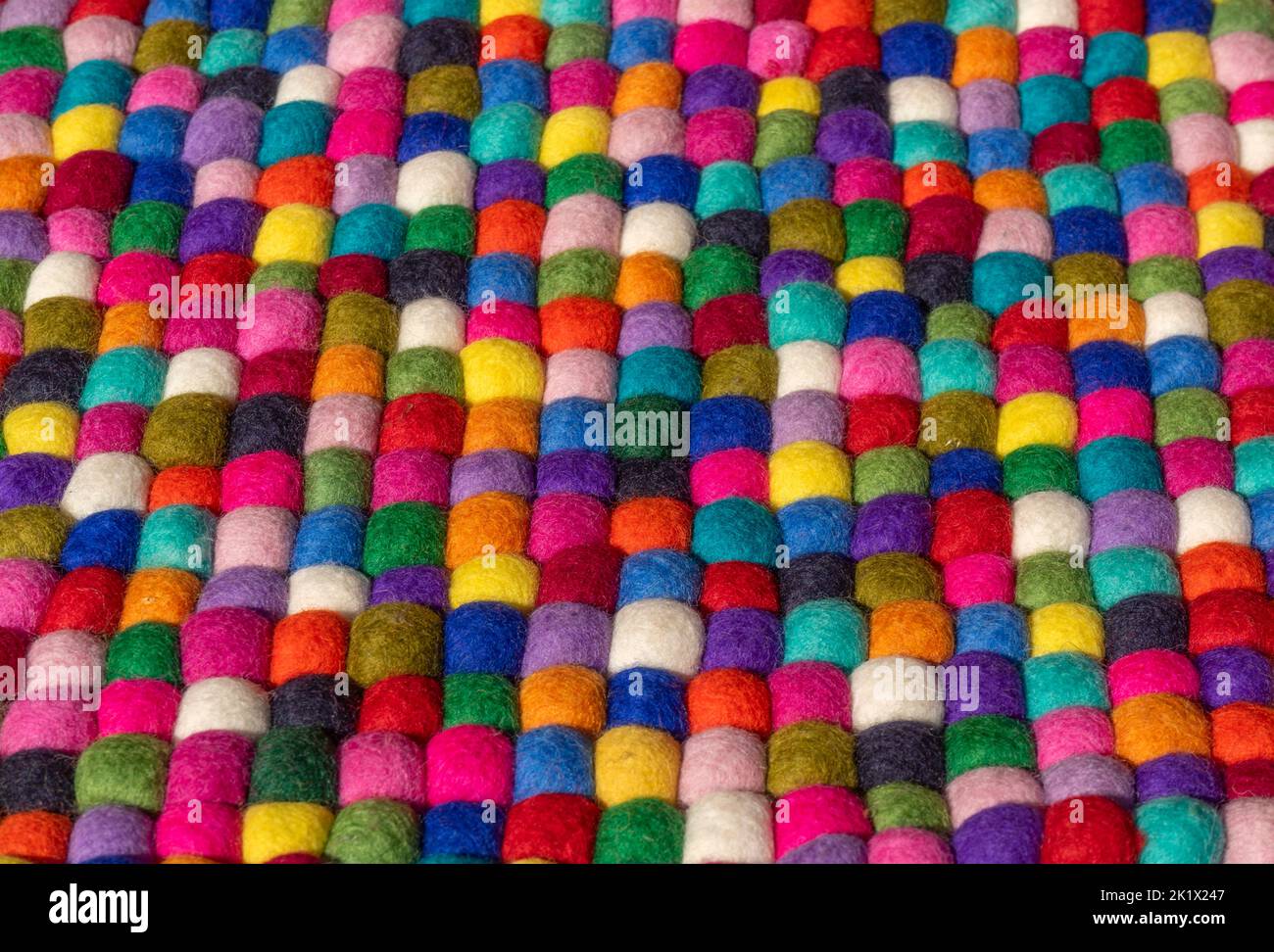 Un montón de bolas de fieltro de colores lado a lado Foto de stock