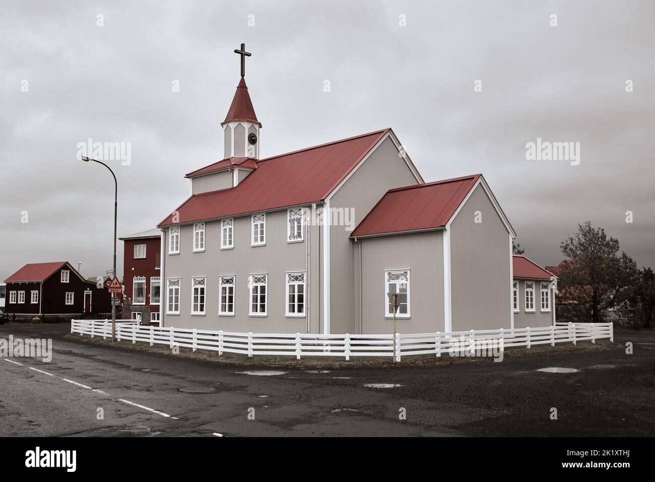 Pequeña iglesia Eyrarbakkakirkja y la calle principal, Eyrarbakki, Islandia del Sur Foto de stock