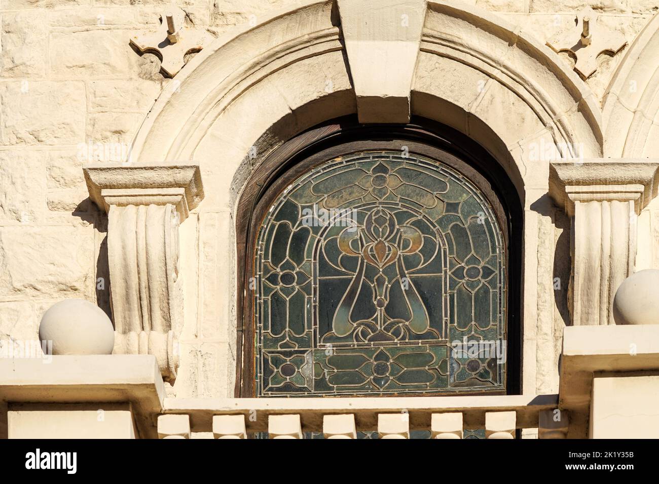 vidrieras en un arco de un antiguo edificio histórico rodeado de piedra decorativa Foto de stock
