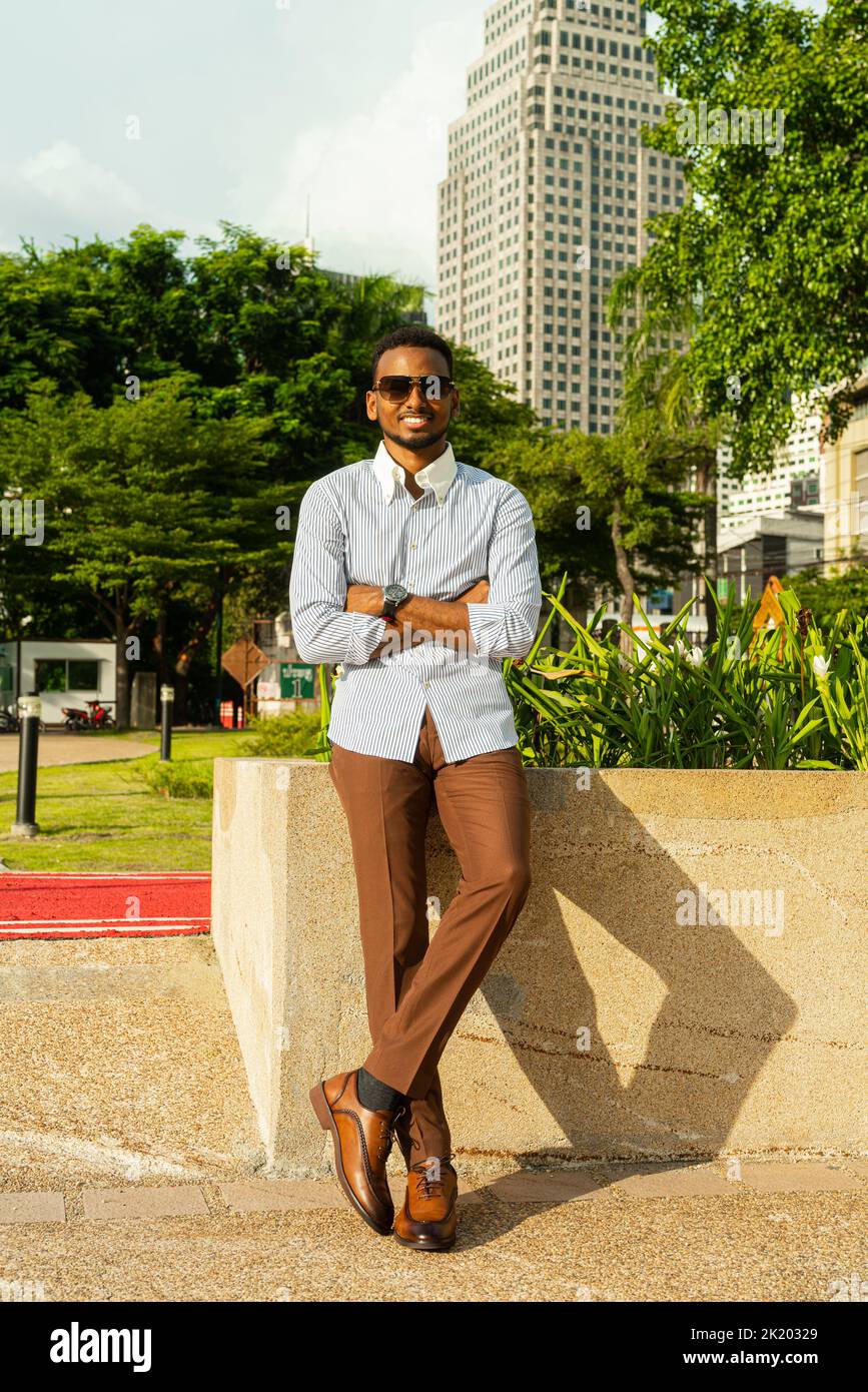 Retrato de un joven hombre de negocios negro en el parque al aire libre durante el verano Foto de stock