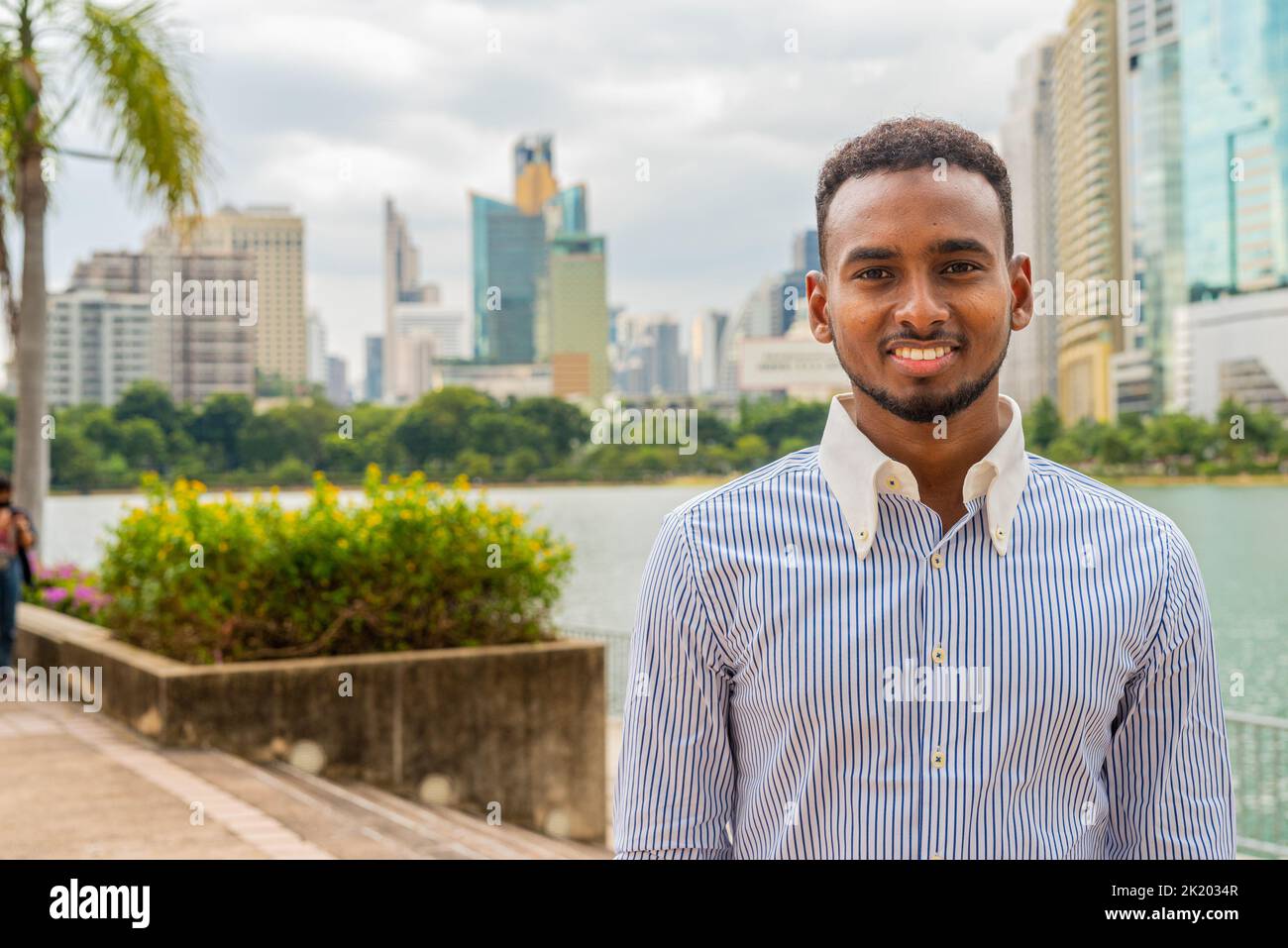 Retrato de un joven hombre de negocios negro en el parque al aire libre durante el verano Foto de stock
