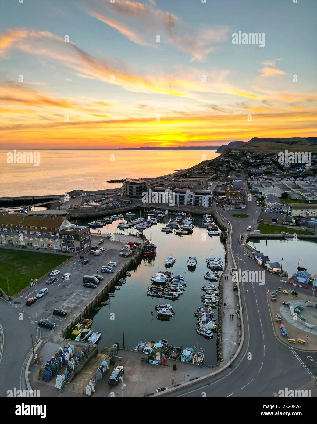 West Bay, Dorset, Reino Unido. 21st de septiembre de 2022. Clima en el Reino Unido. Vista desde el aire de la espectacular puesta de sol naranja sobre el puerto en la localidad costera de West Bay en Dorset al final de un caluroso y soleado día de otoño. Crédito de la imagen: Graham Hunt/Alamy Live News Foto de stock
