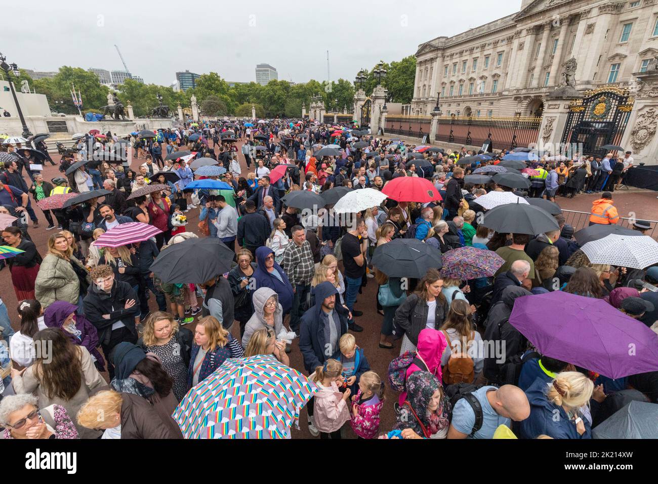 Las multitudes esperan en las puertas del Palacio de Buckingham para llegar bajo la lluvia. La nación continúa llorando la muerte de la Reina Isabel II Captura de imagen Foto de stock