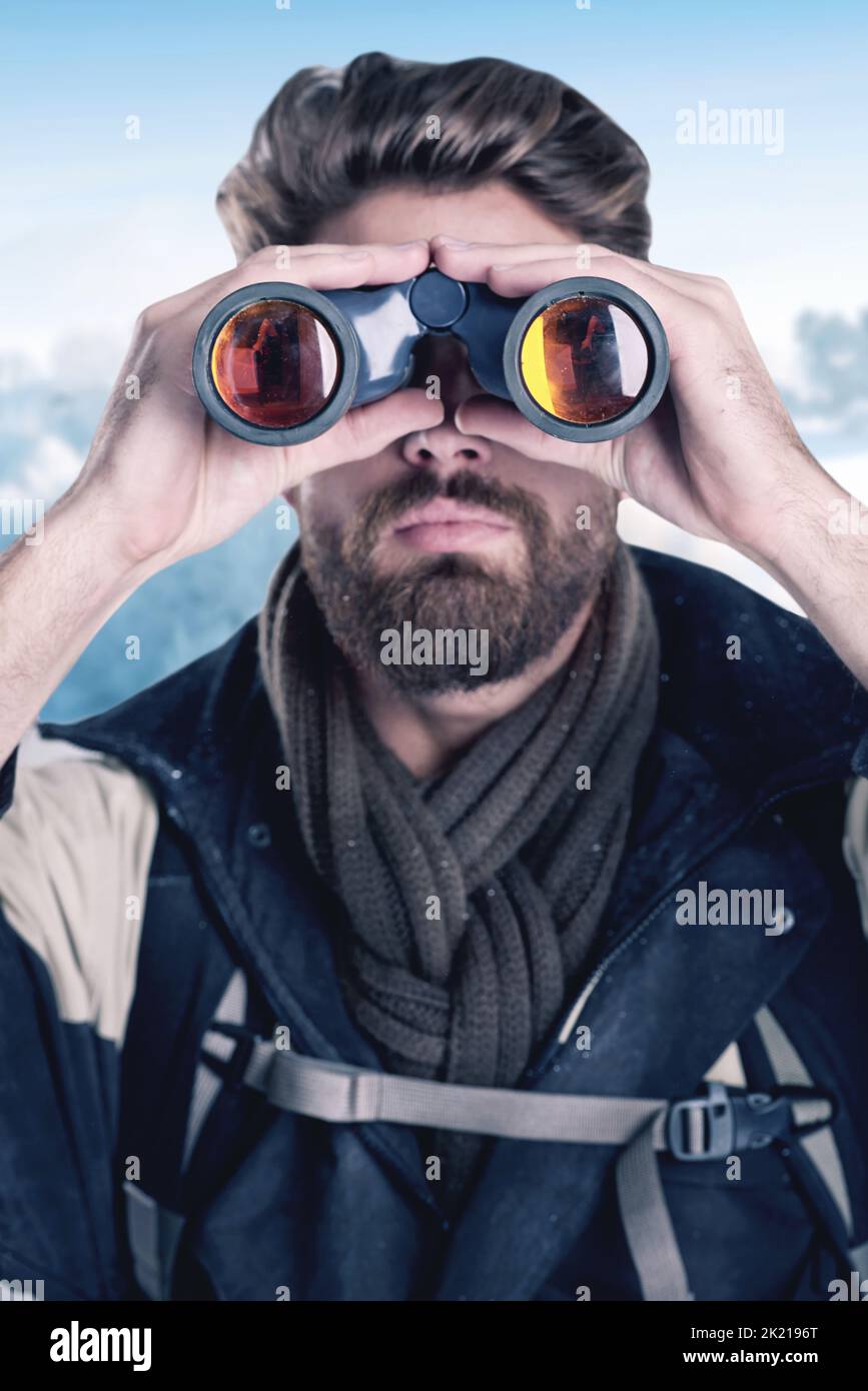 Listo para encontrar el próximo desafío. Excursionista mirando a través de binoculares en un paisaje remoto. Foto de stock