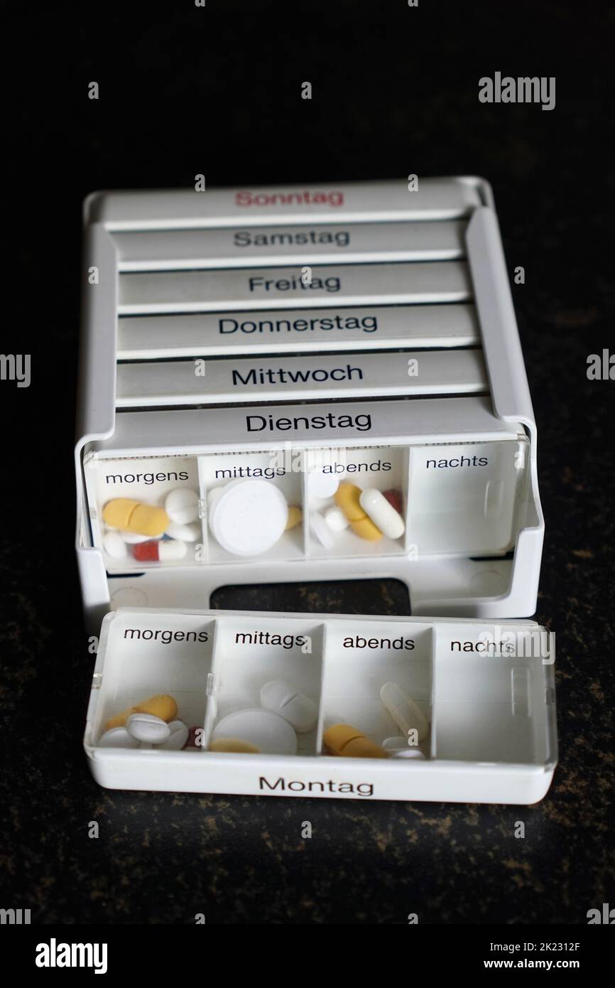caja de organizador alemán de la píldora para clasificar dosis diarias y semanales de la medicación Foto de stock