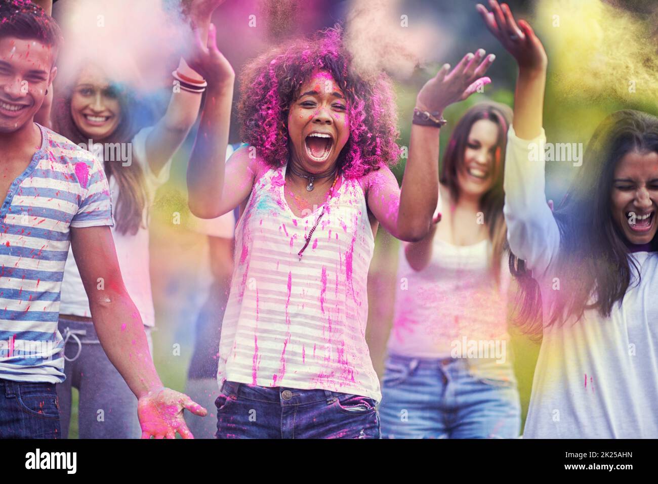 Color Me emocionado. Retrato de un grupo de amigos que se divierten al aire libre en un festival de color. Foto de stock
