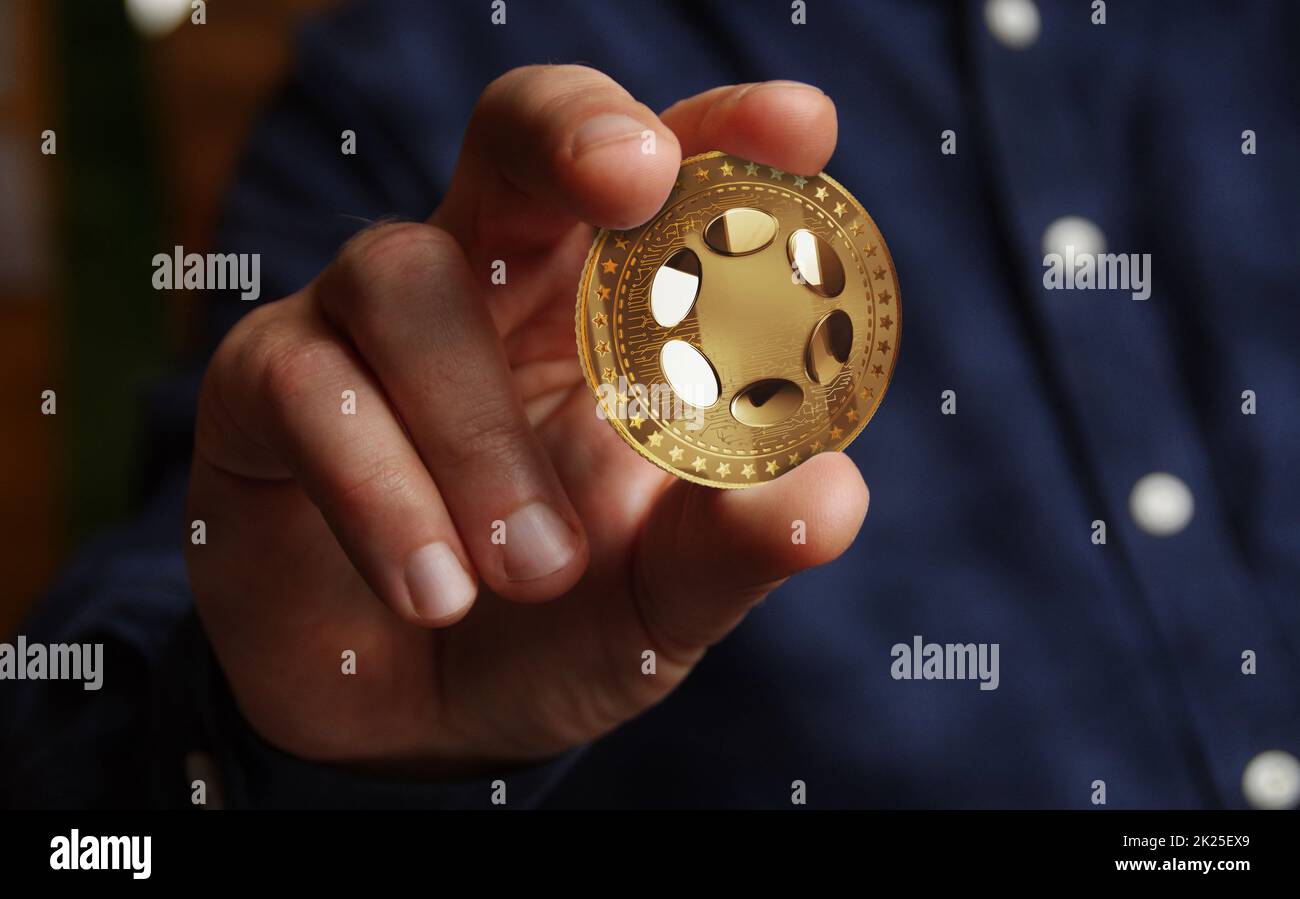 Polkadot DOT criptomoneda de oro en concepto abstracto de la mano Foto de stock
