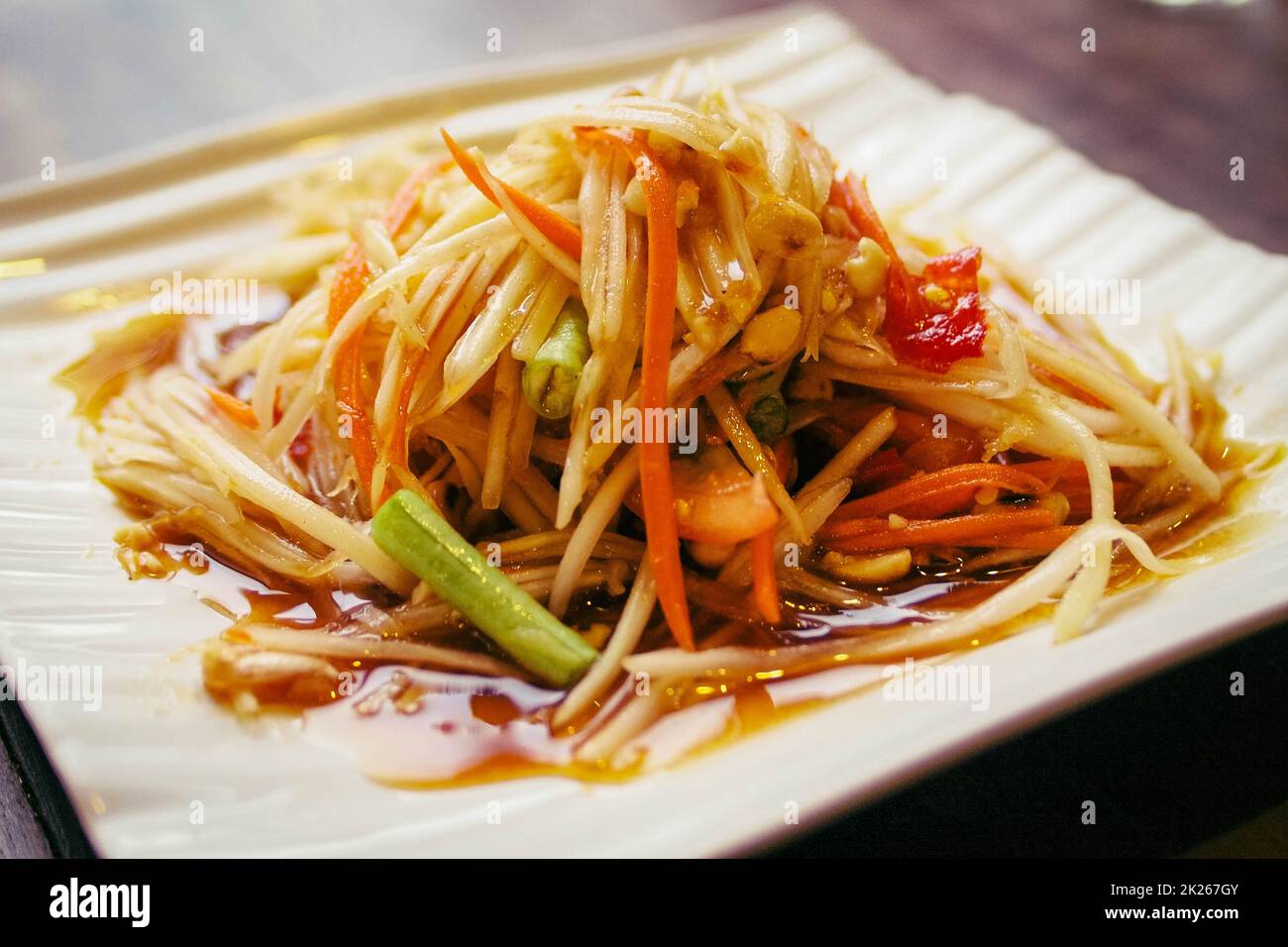 ensalada de papaya thai y asia mejor plato sobre blanco la placa cerámica todavía tiene vida útil Foto de stock