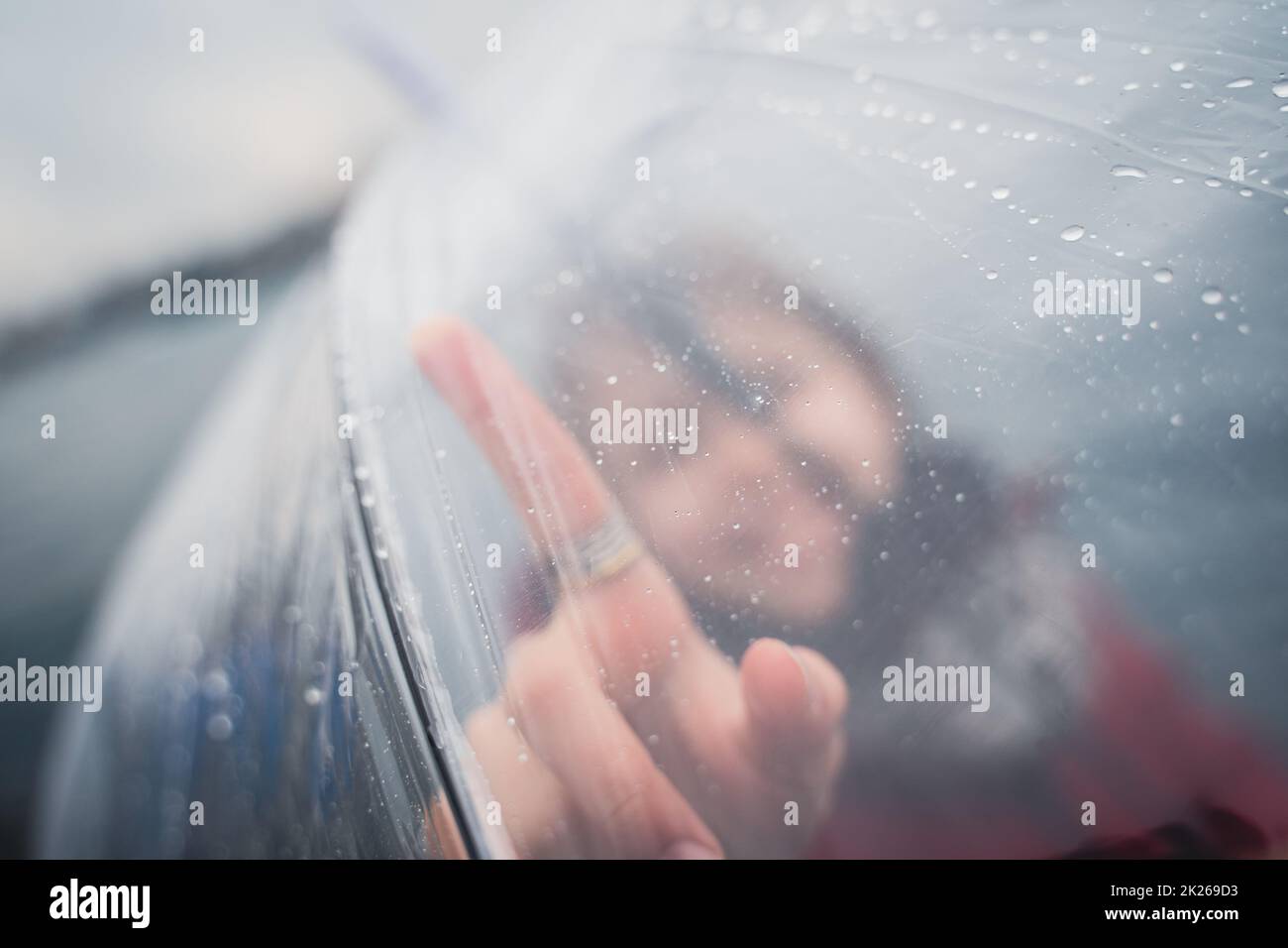 niña sosteniendo un paraguas transparente y señalando con el dedo Foto de stock