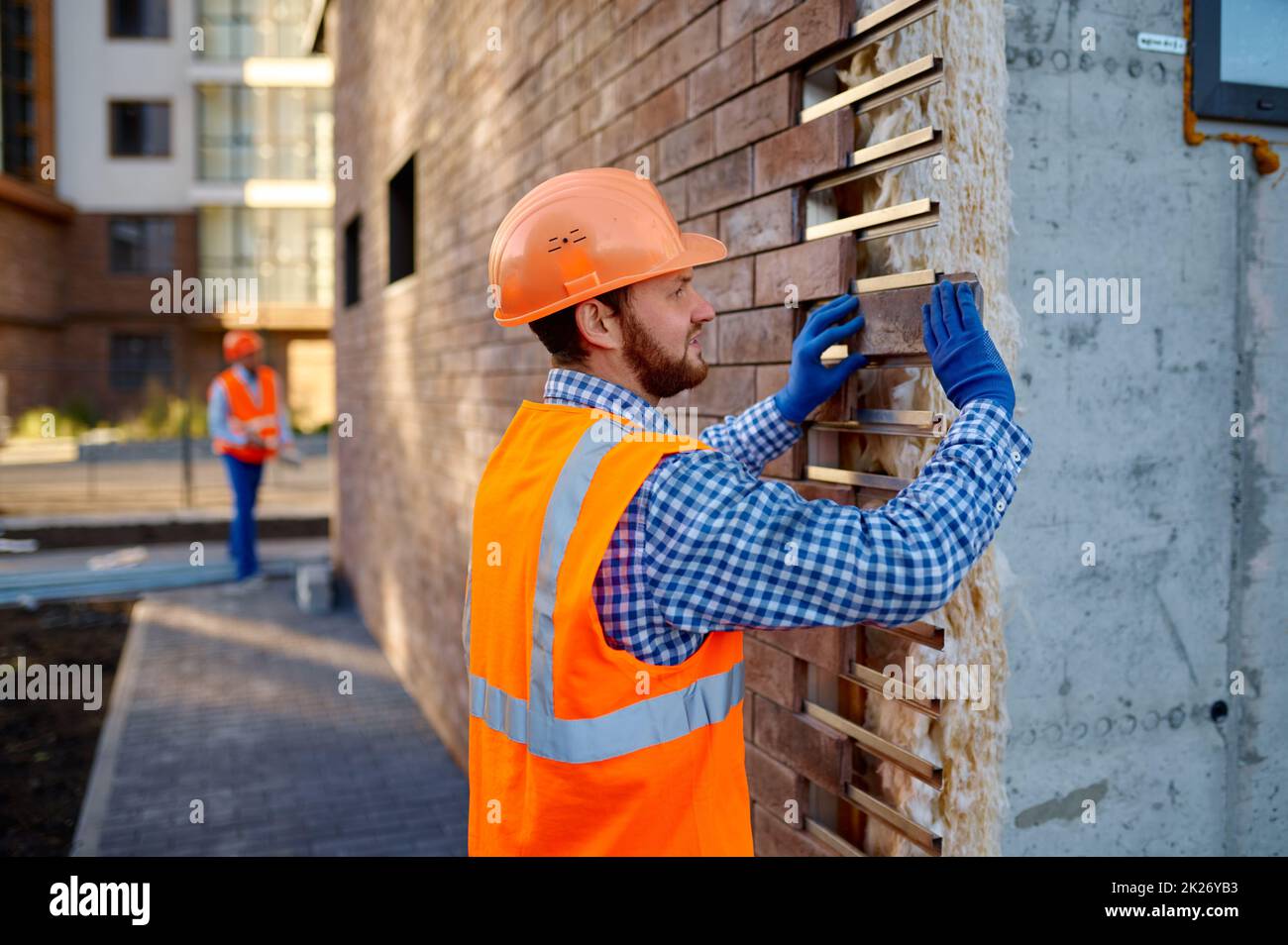 Piedra de revestimiento de trabajadores para el calentamiento de paredes externas Foto de stock