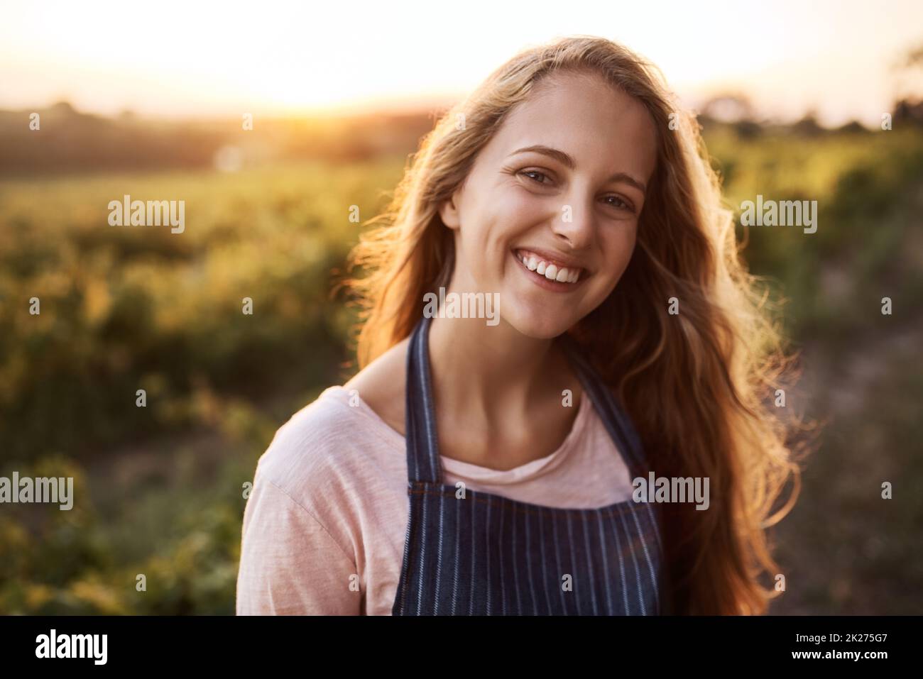 La agricultura es vida. Retrato de una joven feliz trabajando en una granja. Foto de stock