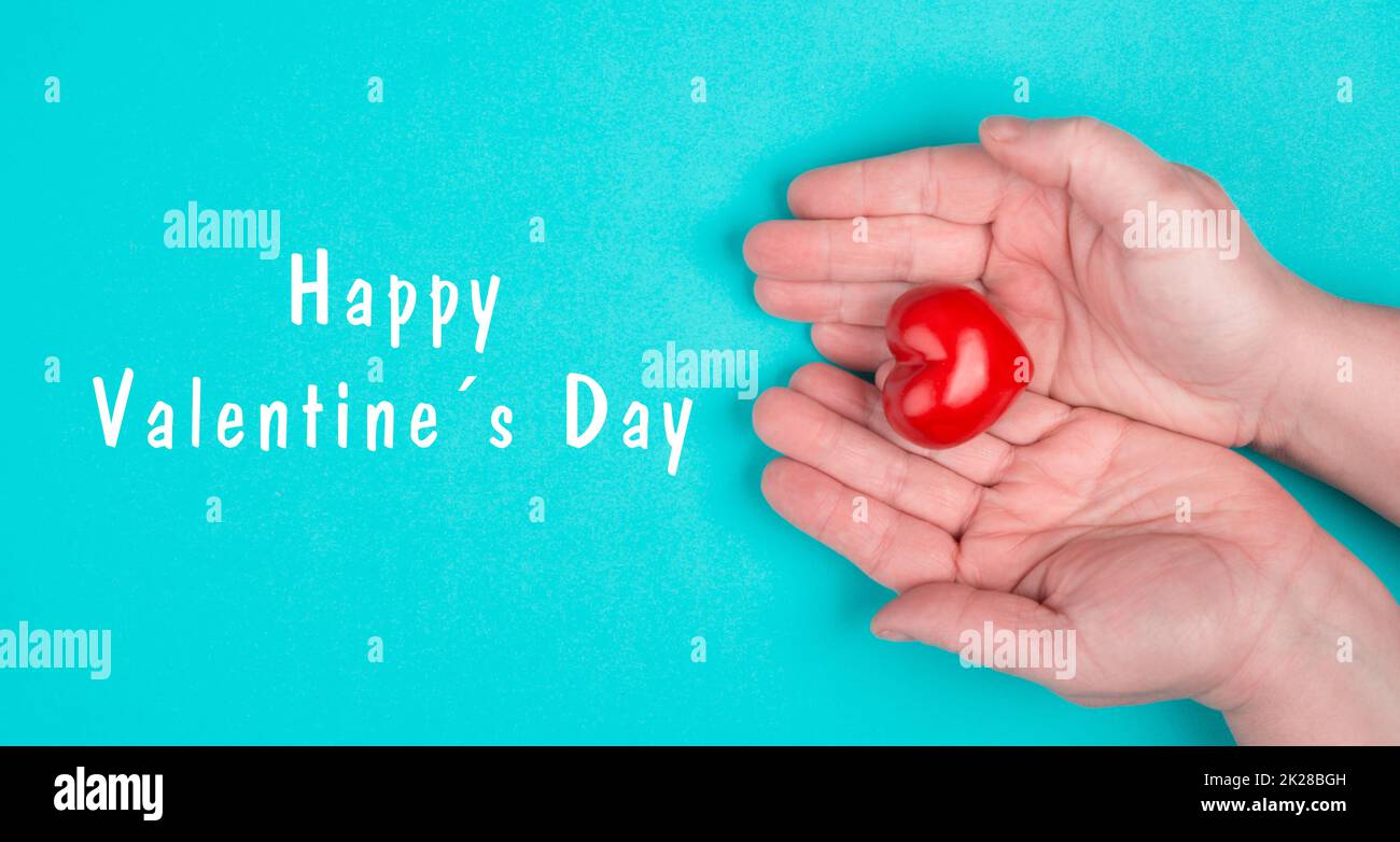 Sosteniendo un corazón en las manos, celebrando el día de San Valentín en febrero, símbolo de amor Foto de stock