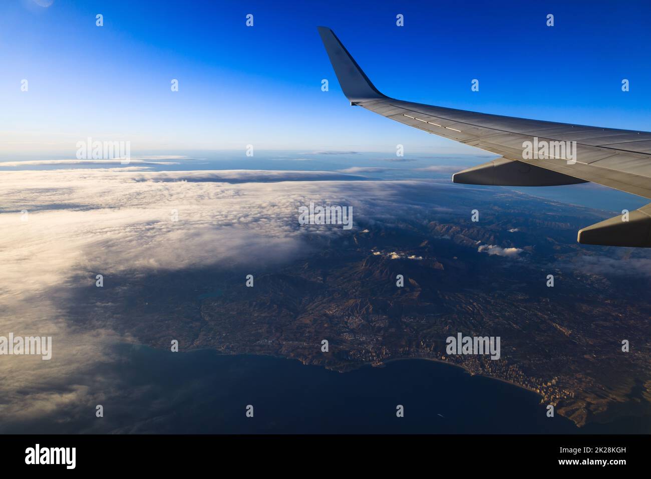 La vista del horizonte a través del cielo azul en el avión durante la luz del día de la noche Foto de stock