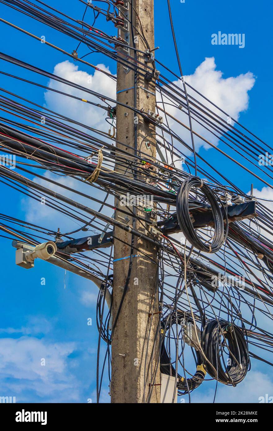 Caos absoluto del cable en el polo de energía tailandés cielo azul de Tailandia. Foto de stock
