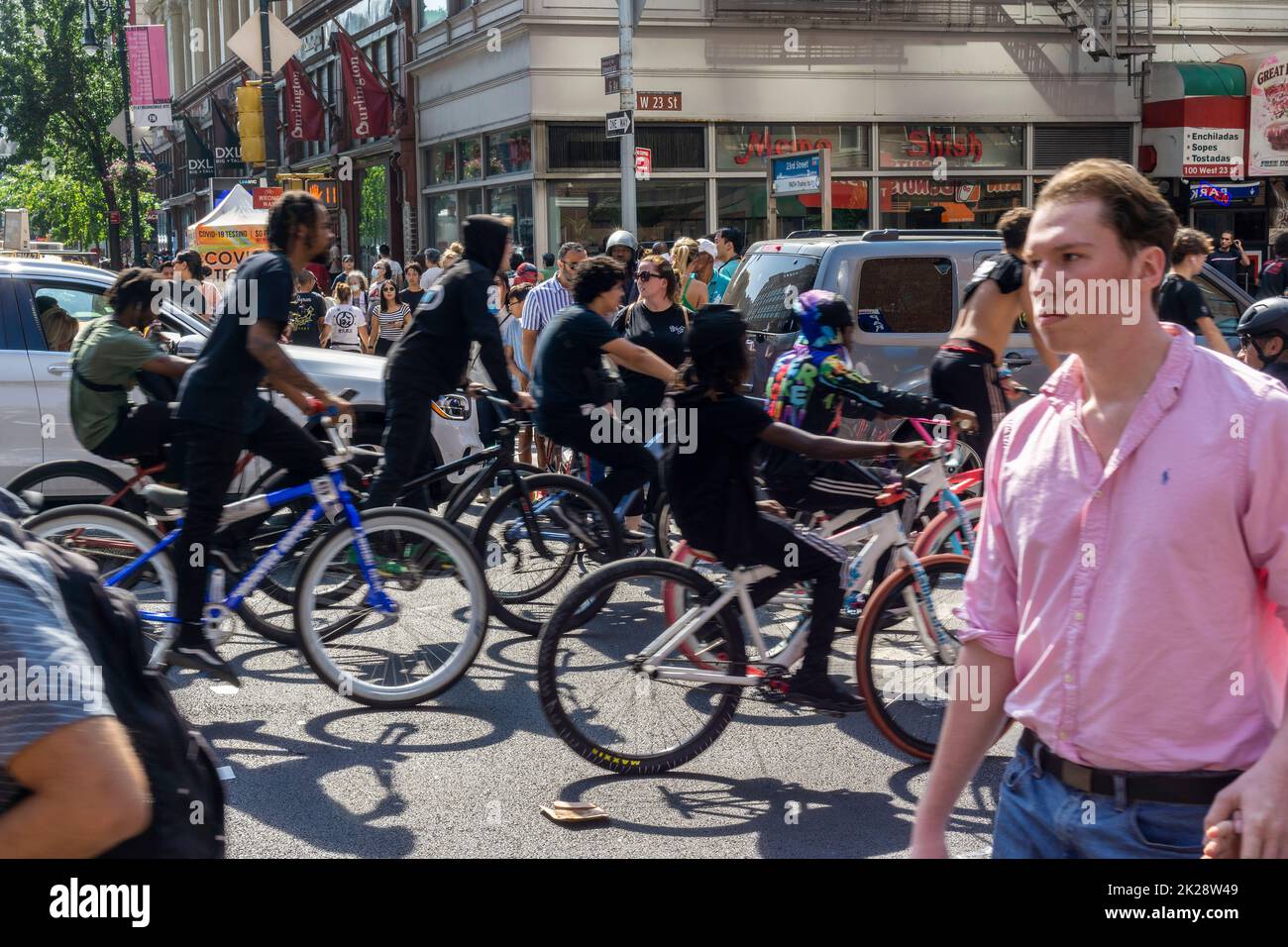 Cientos de personas en bicicletas y motorizadas toman el control de la calle West 23rd Street y la acera en Chelsea en Nueva York mientras viajan en un paquete el domingo, 18 de septiembre de 2022. (© Richard B. Levine) Foto de stock