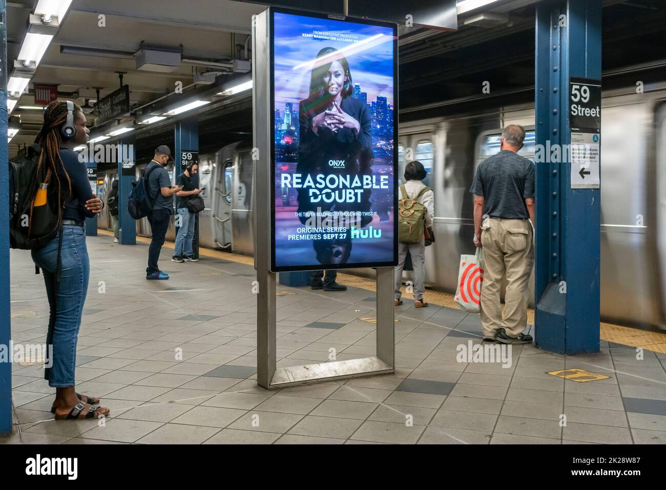 Los viajeros del metro en la estación Columbus Circle-59th Street en Nueva York el miércoles, 14 de septiembre de 2022. Un anuncio digital para el programa de Hulu “Razonable Doubt” está en la plataforma. (© Richard B. Levine) Foto de stock