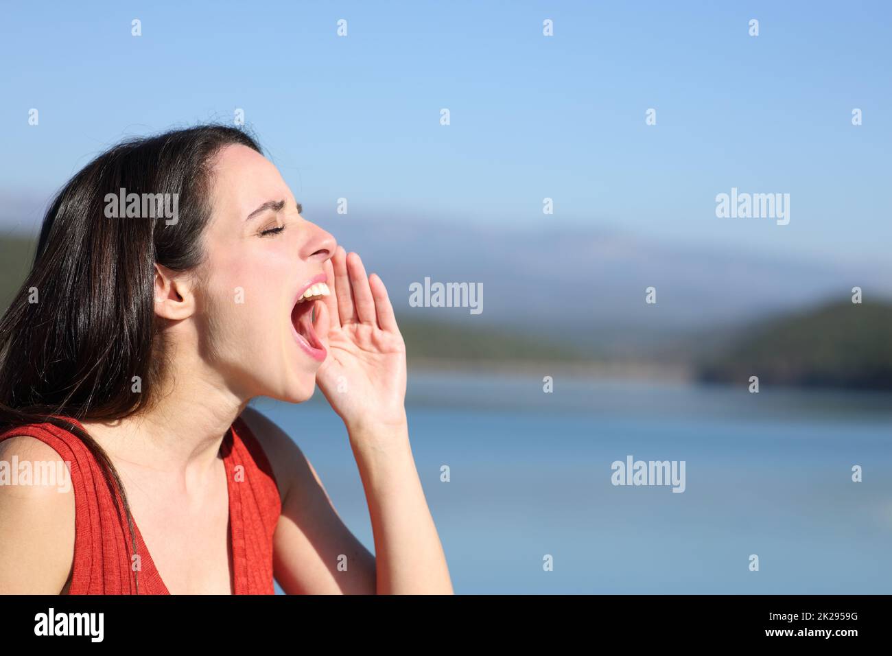 Mujer gritando fuerte en un lago Foto de stock