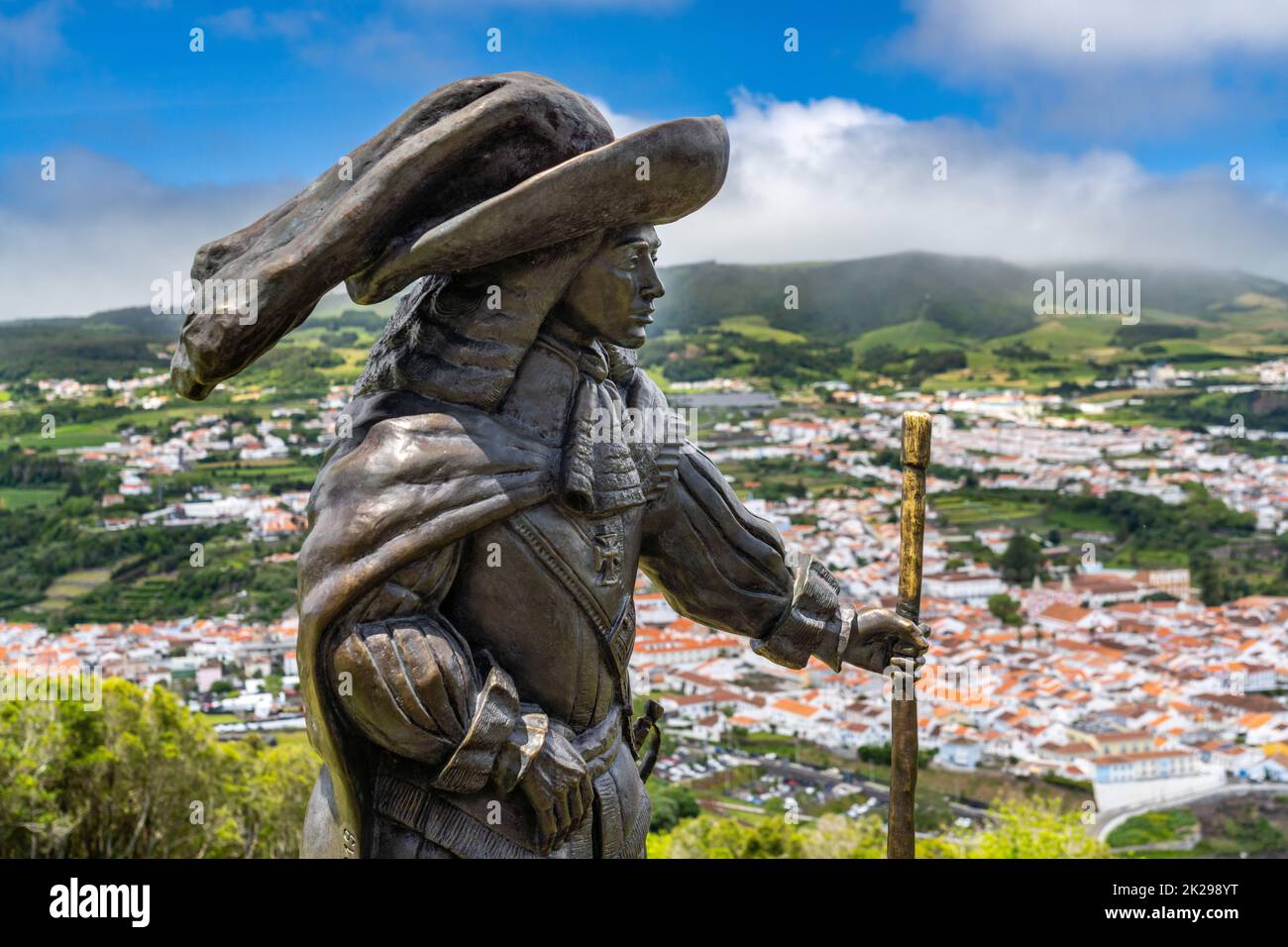 Estatua de Afonso VI Segundo Rey de Portugal en Monte Brasil con vista al centro histórico de la ciudad, playa pública llamada Praia de Angra do Heroismo abajo, en Angra do Heroismo, Isla Terceira, Azores, Portugal. Foto de stock