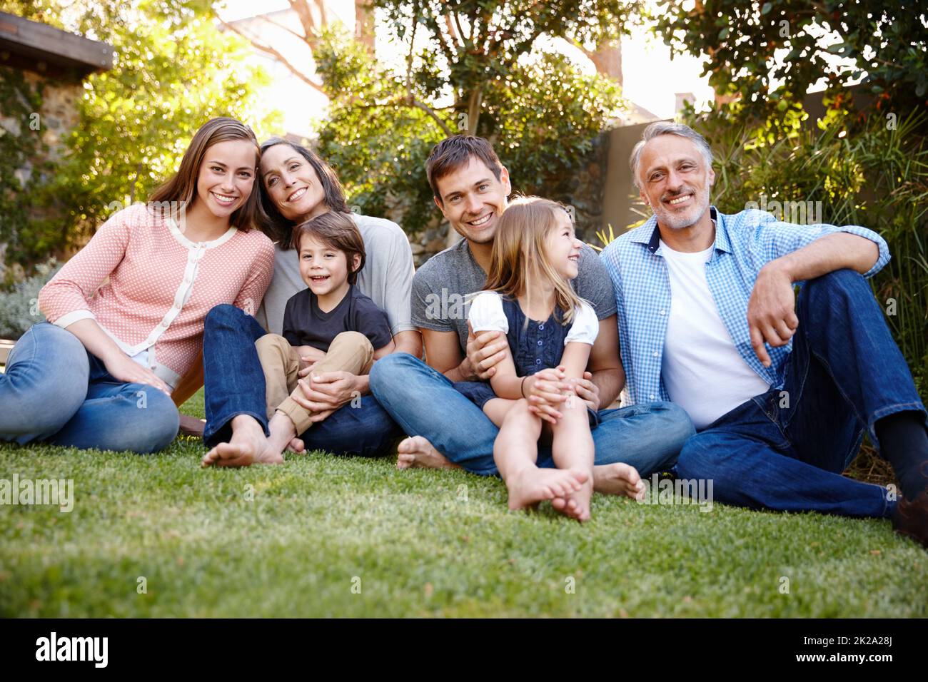 Juntos lo tenemos todo. Retrato de una familia multigeneracional sentada en su jardín. Foto de stock