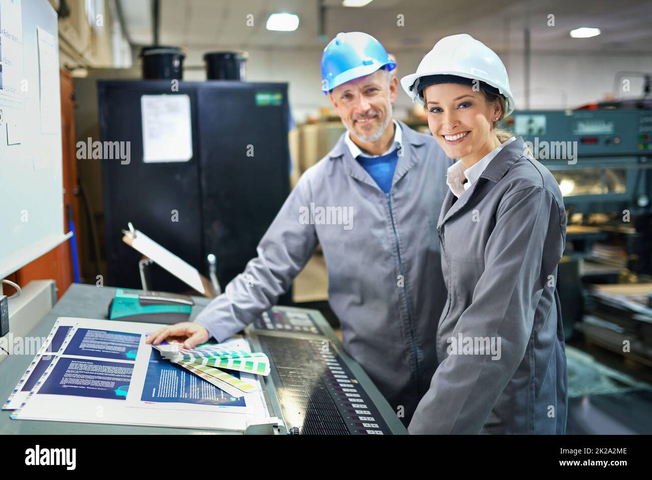 Retrato de una gente que trabaja dentro de una fábrica de impresión, embalaje y distribución. Los diseños comerciales que se muestran en esta imagen representan una simulación de un producto real y han sido modificados o alterados lo suficiente por nuestro equipo de retoque y diseño Foto de stock