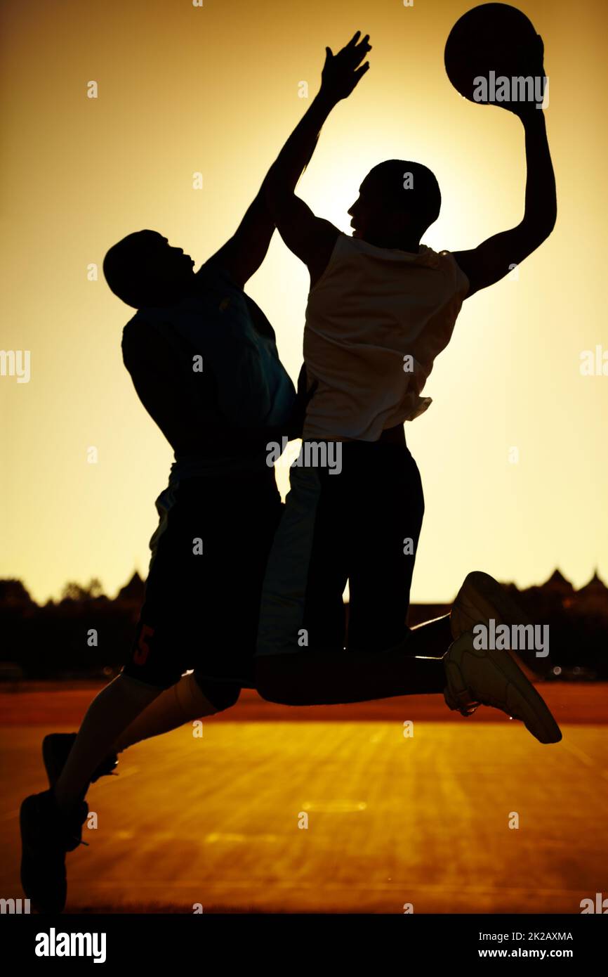 Una competencia sana. Las siluetas de dos jugadores de baloncesto. Foto de stock